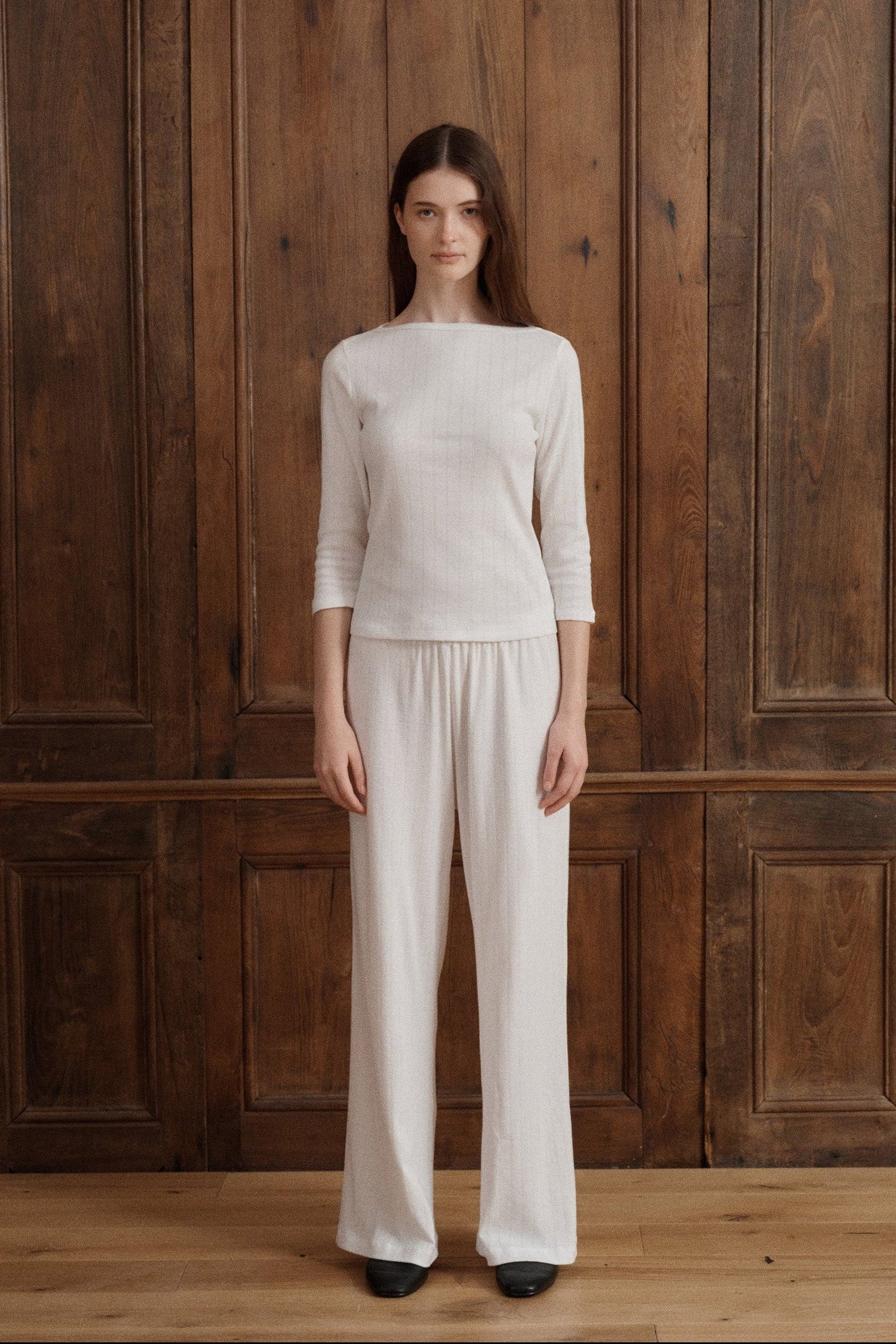Female model wearing a 100% cotton pointelle lounge set in white featuring a relaxed wide leg elastic waist lounge pant and a three-quarter sleeve boatneck pointelle top paired with black flats. - VIR VITA
#color_coconut