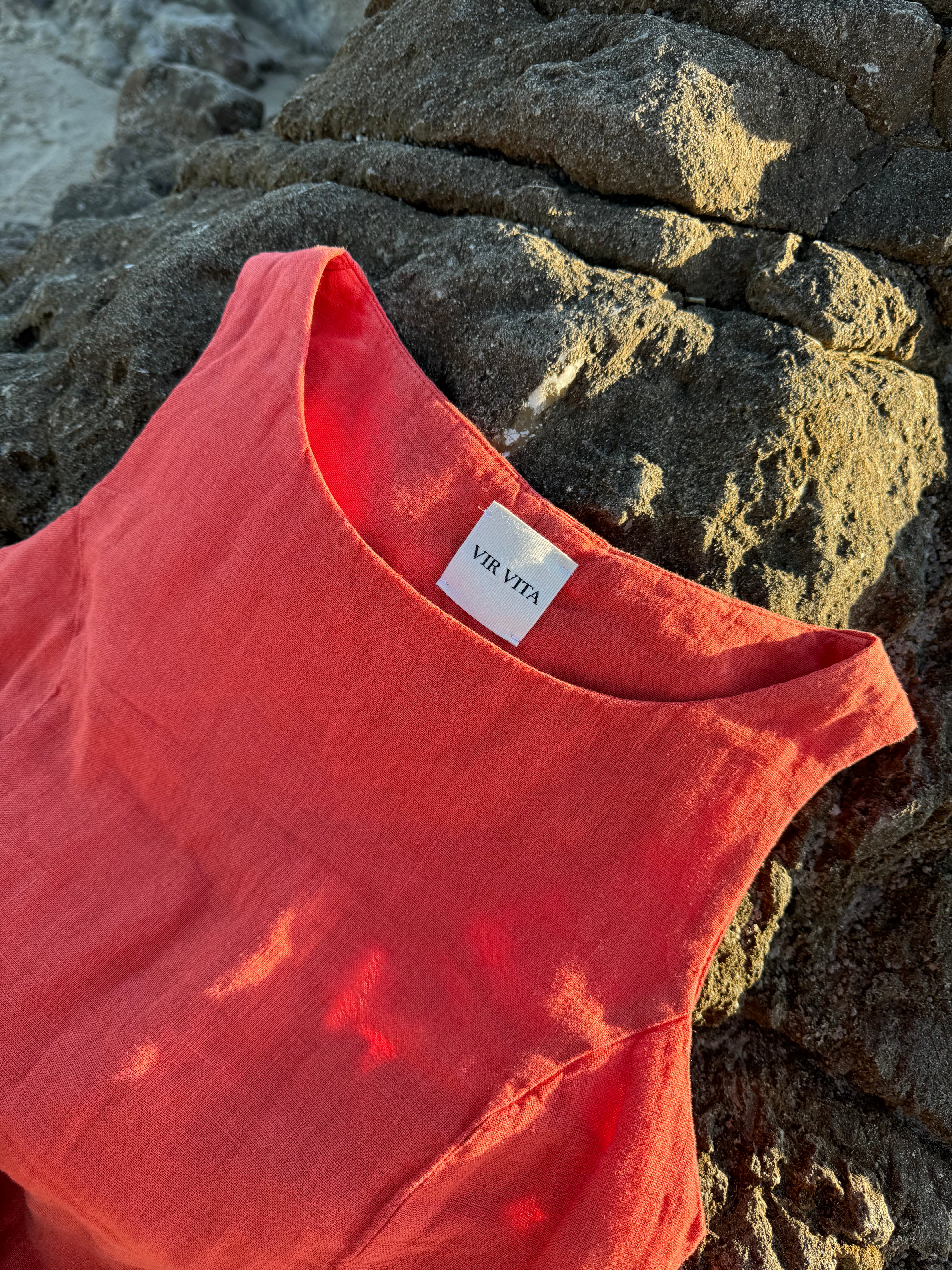 Sustainable orange 100% linen dress with a simple and comfortable silhouette on rocks at the ocean made in europe - VIR VITA
#color_cayenne