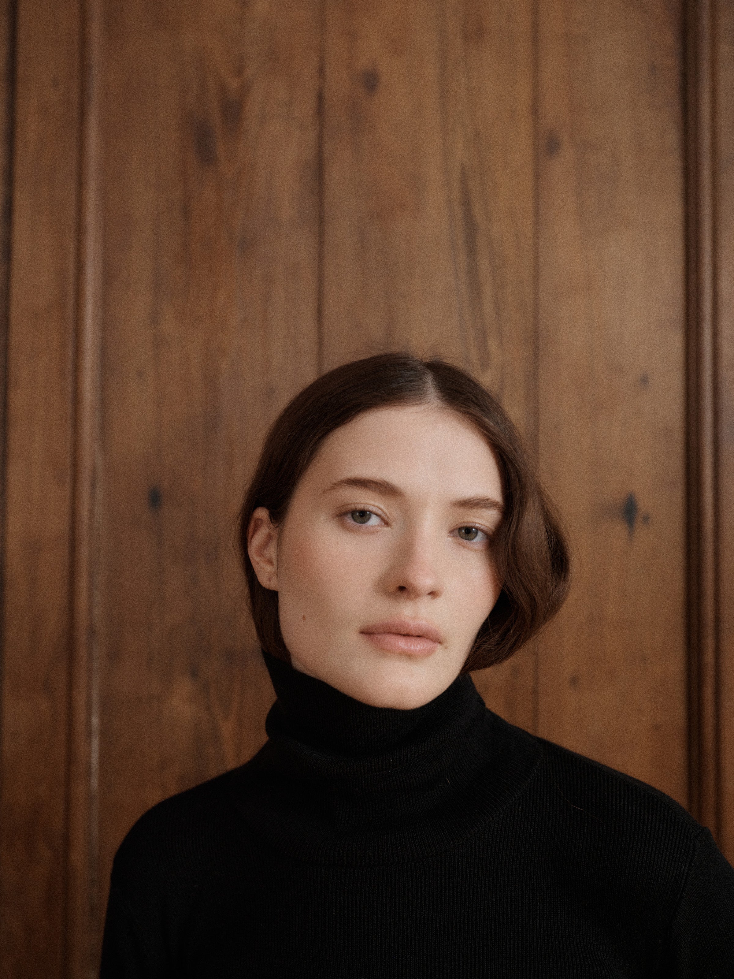 Female model posing wearing a black fitted turtleneck crafted from a fine wool, cashmere and silk blend. - VIR VITA
#color_black