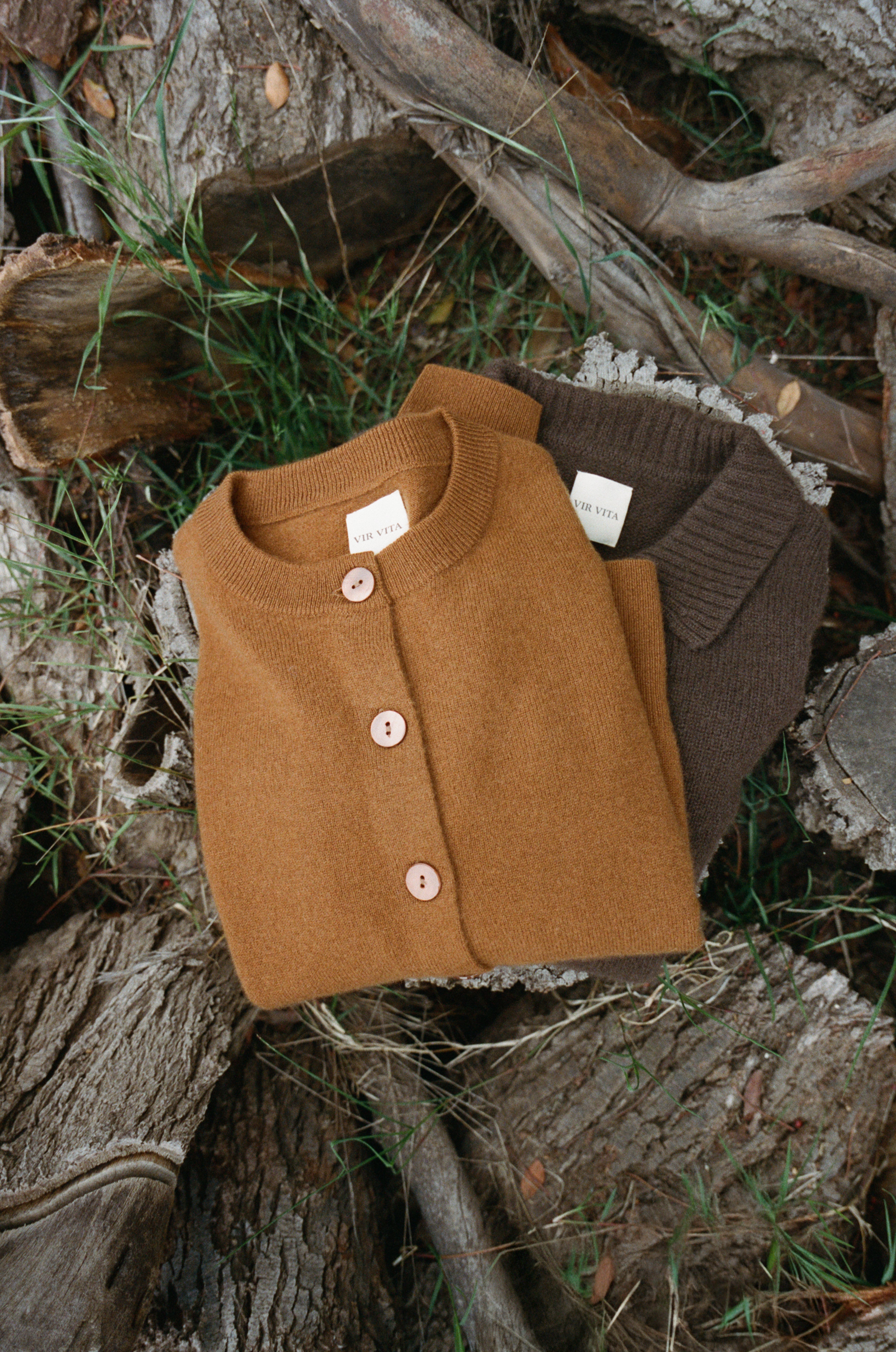 Brown ultra-soft luxurious cashmere button up cardigan folded and laid flat on top of a wooden log - VIR VITA
#color_fawn