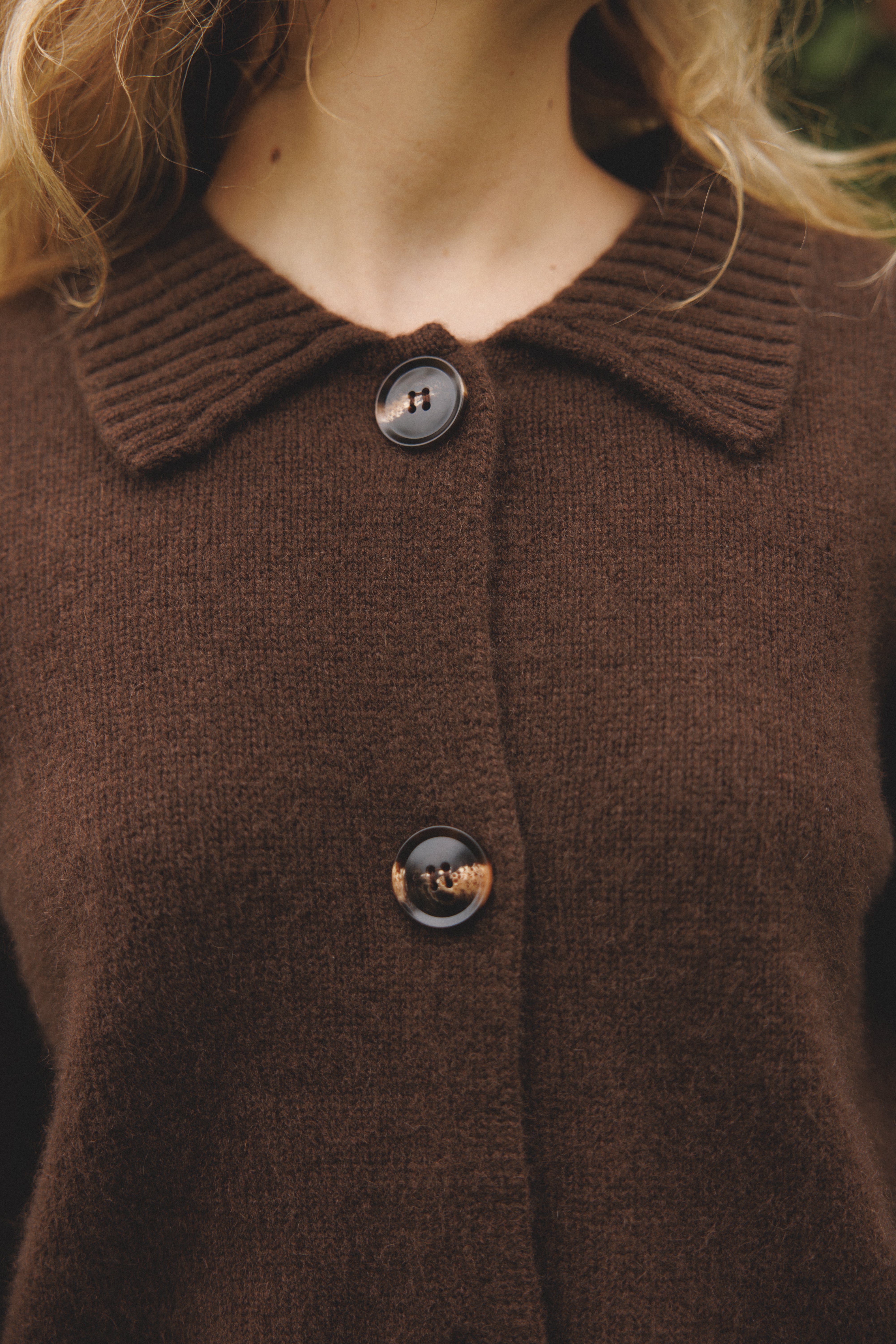 Female model wearing a dark brown ultra-soft luxurious cashmere cardigan featuring a classic silhouette with a collar and large buttons - VIR VITA
#color_espresso