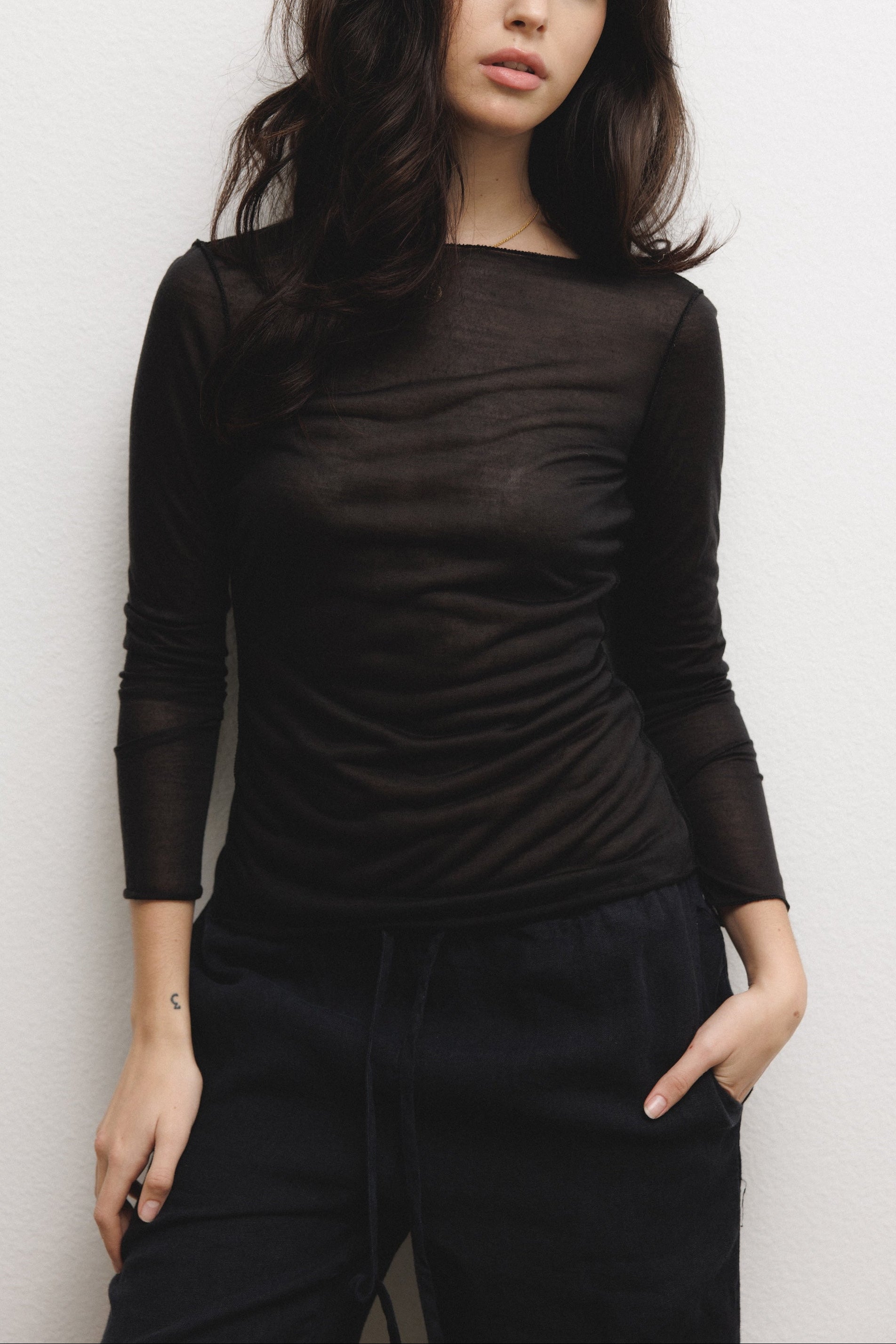 Female model wearing a luxurious lightweight black modal silk long sleeve knit top with a ribbed back- VIR VITA
#color_black