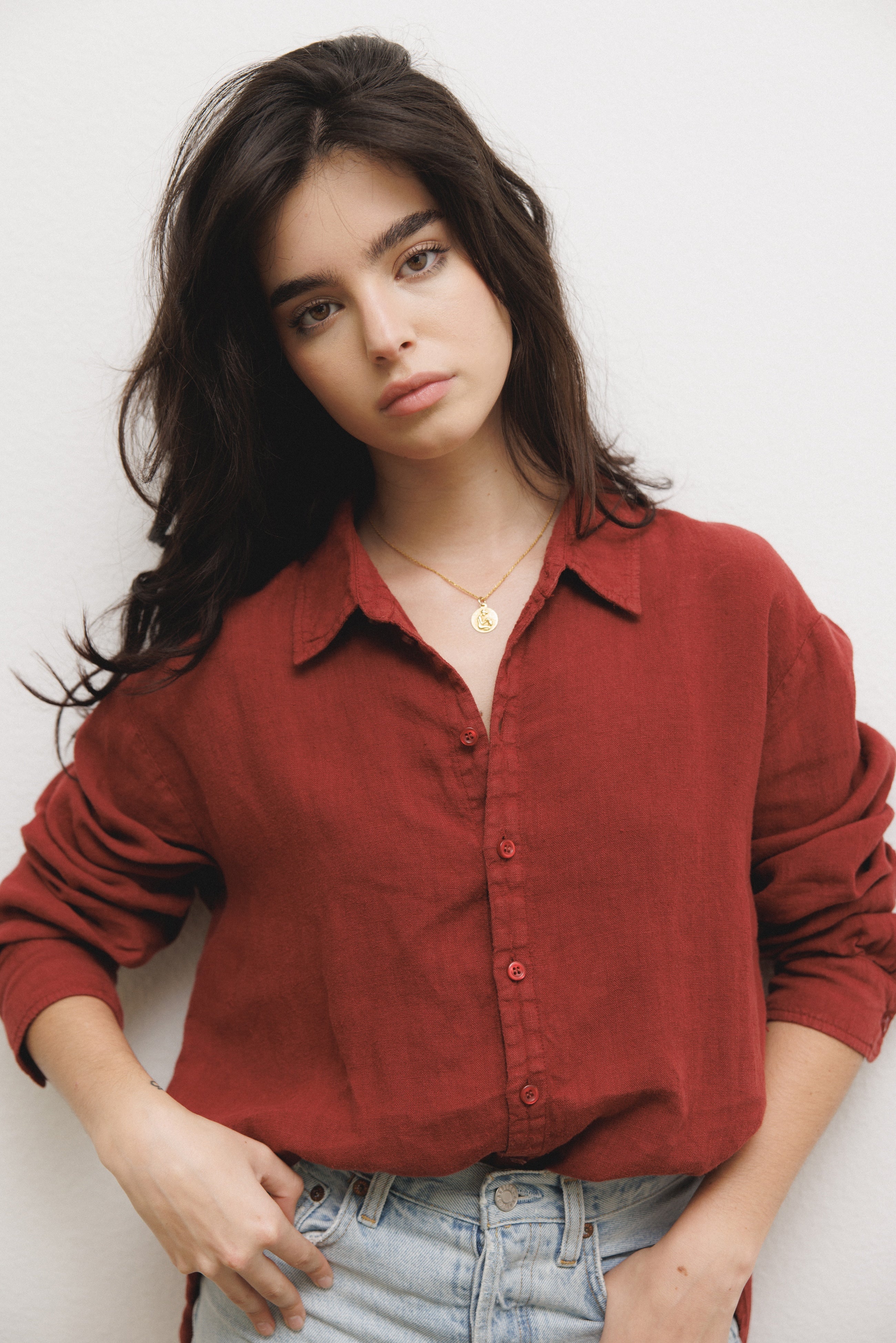 Female model, wearing a dark red colored sustainable oversized 100% linen button down long sleeve paired with blue denim shorts - VIR VITA
#color_sun dried tomato
