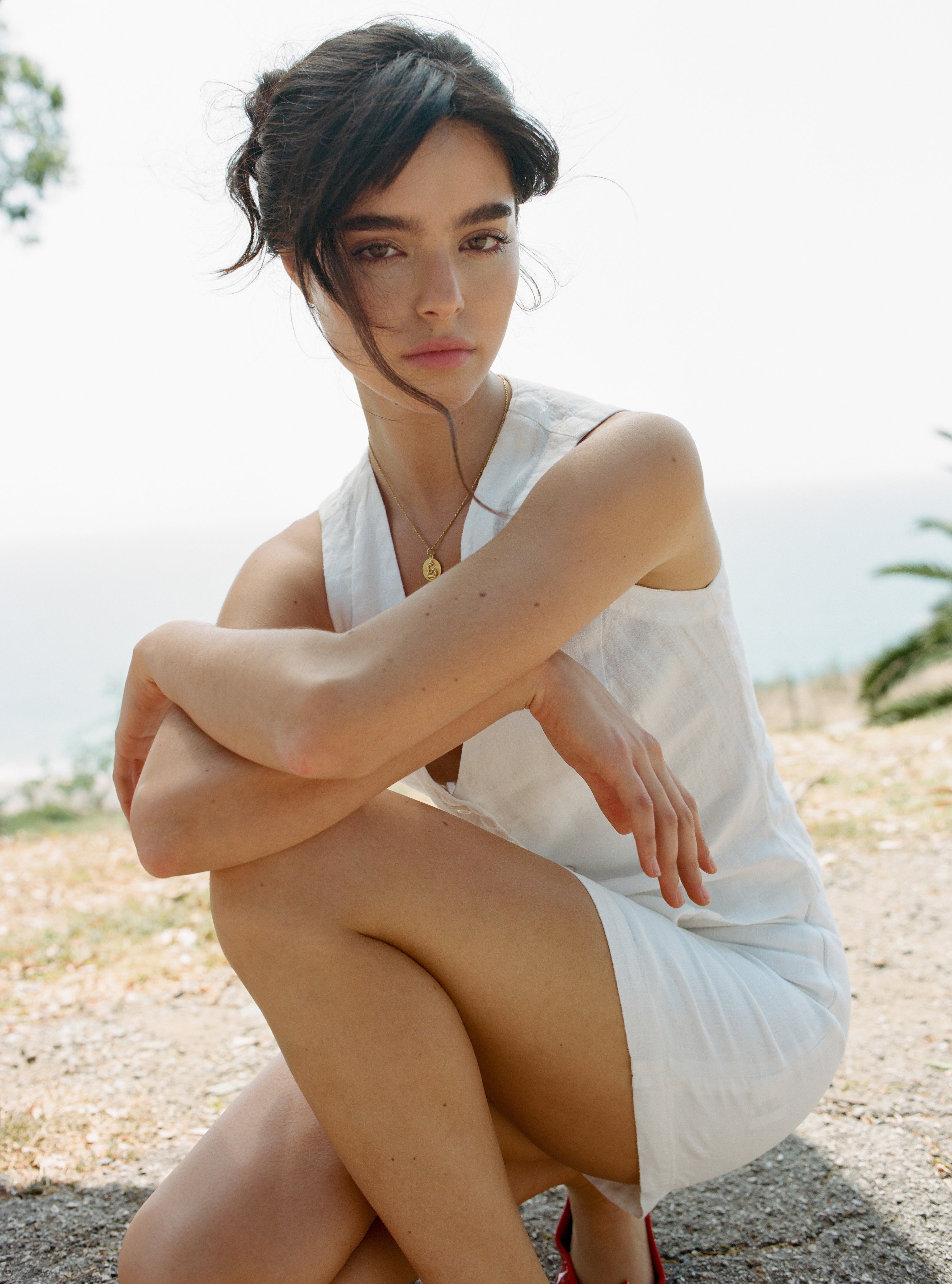 Female model, wearing a white colored sustainable 100% linen vest with matching handcrafted Italian handcrafted buttons paired with a white linen mini skirt - VIR VITA
#color_white
