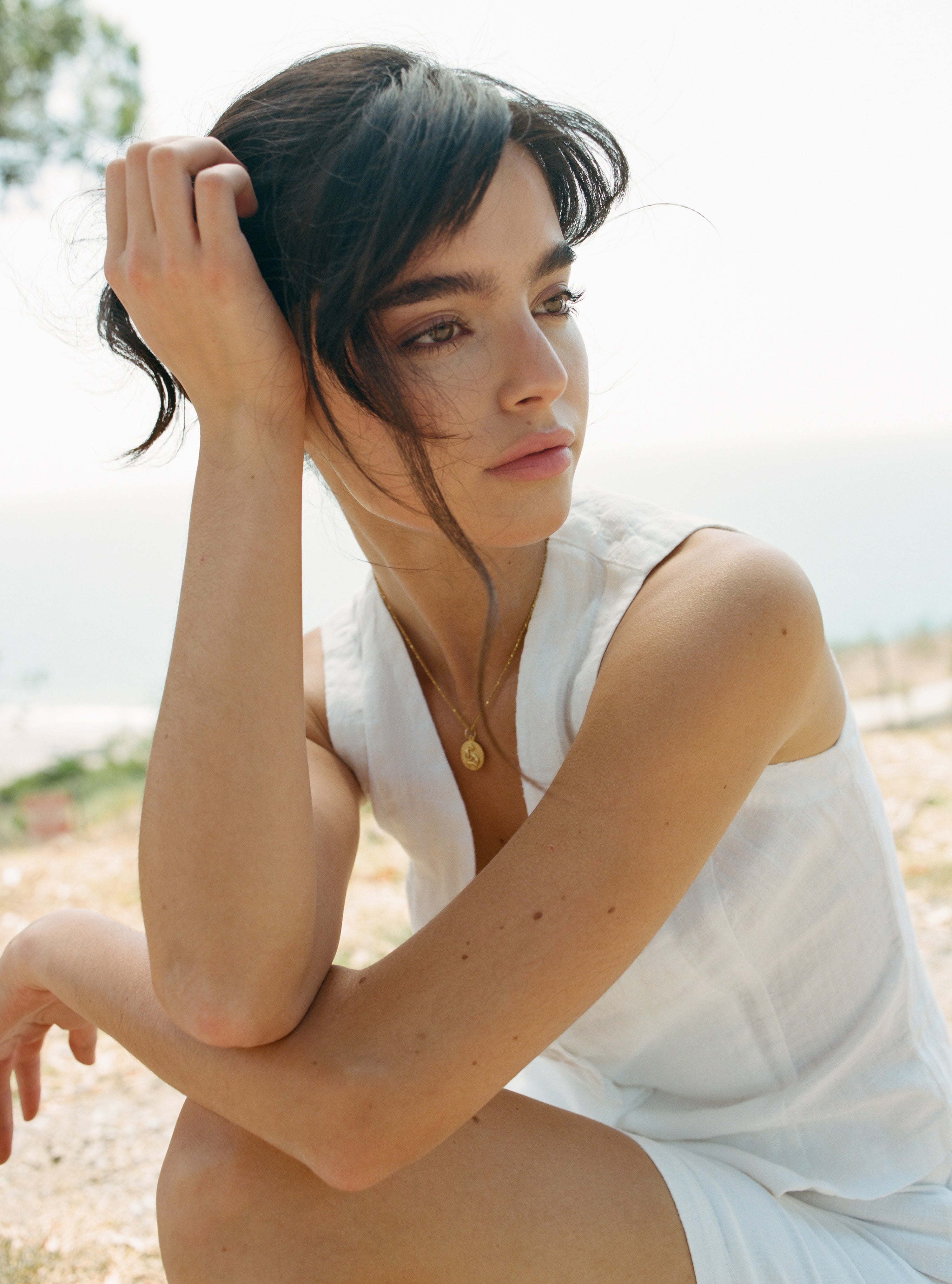 Female model, wearing a white colored sustainable 100% linen vest with matching Italian handcrafted buttons paired with a white linen mini skirt - VIR VITA
#color_white