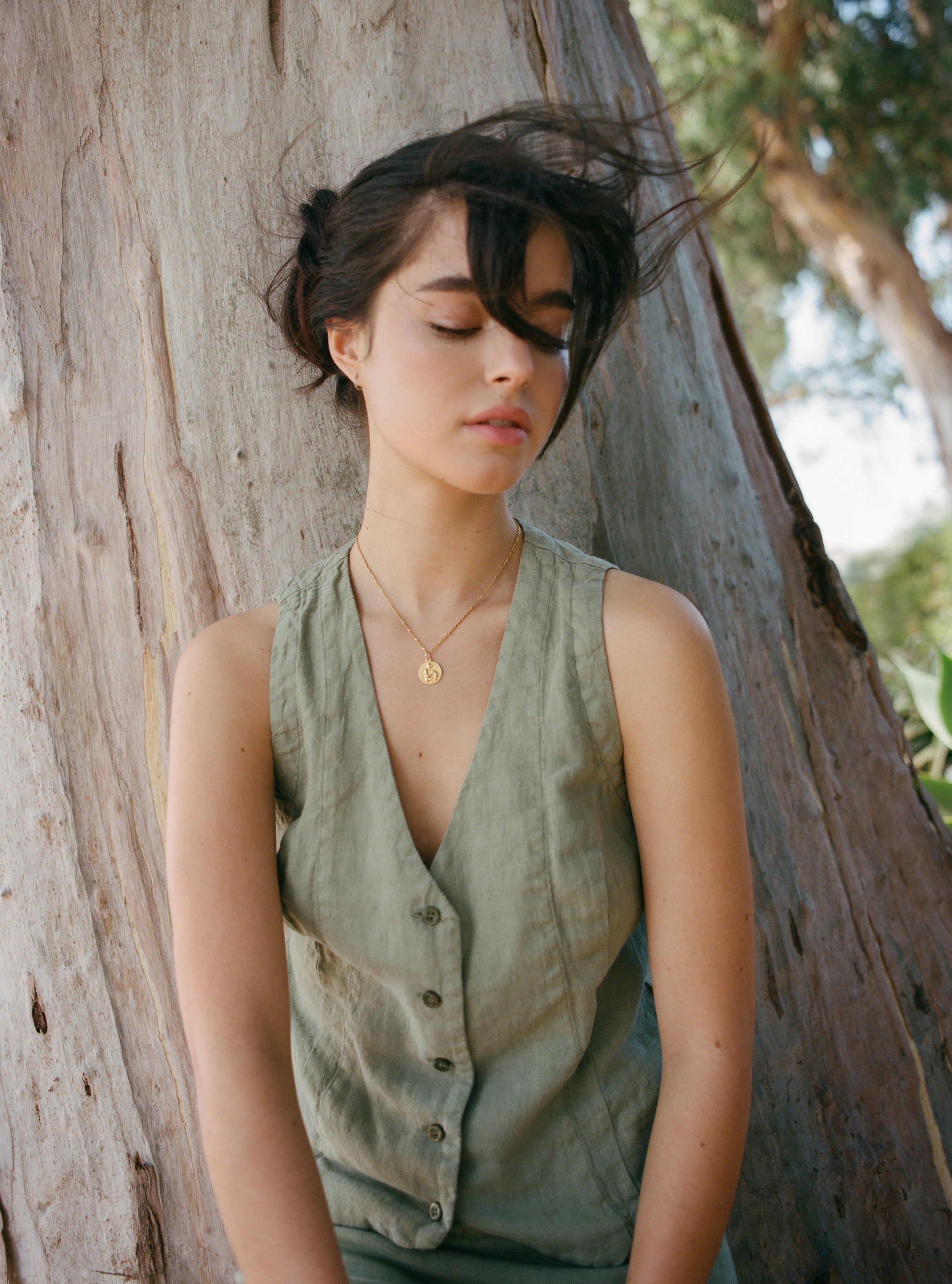 Female model, wearing a sage green colored sustainable 100% linen vest with matching Italian handcrafted buttons paired with a sage green linen skirt - VIR VITA
#color_sage
