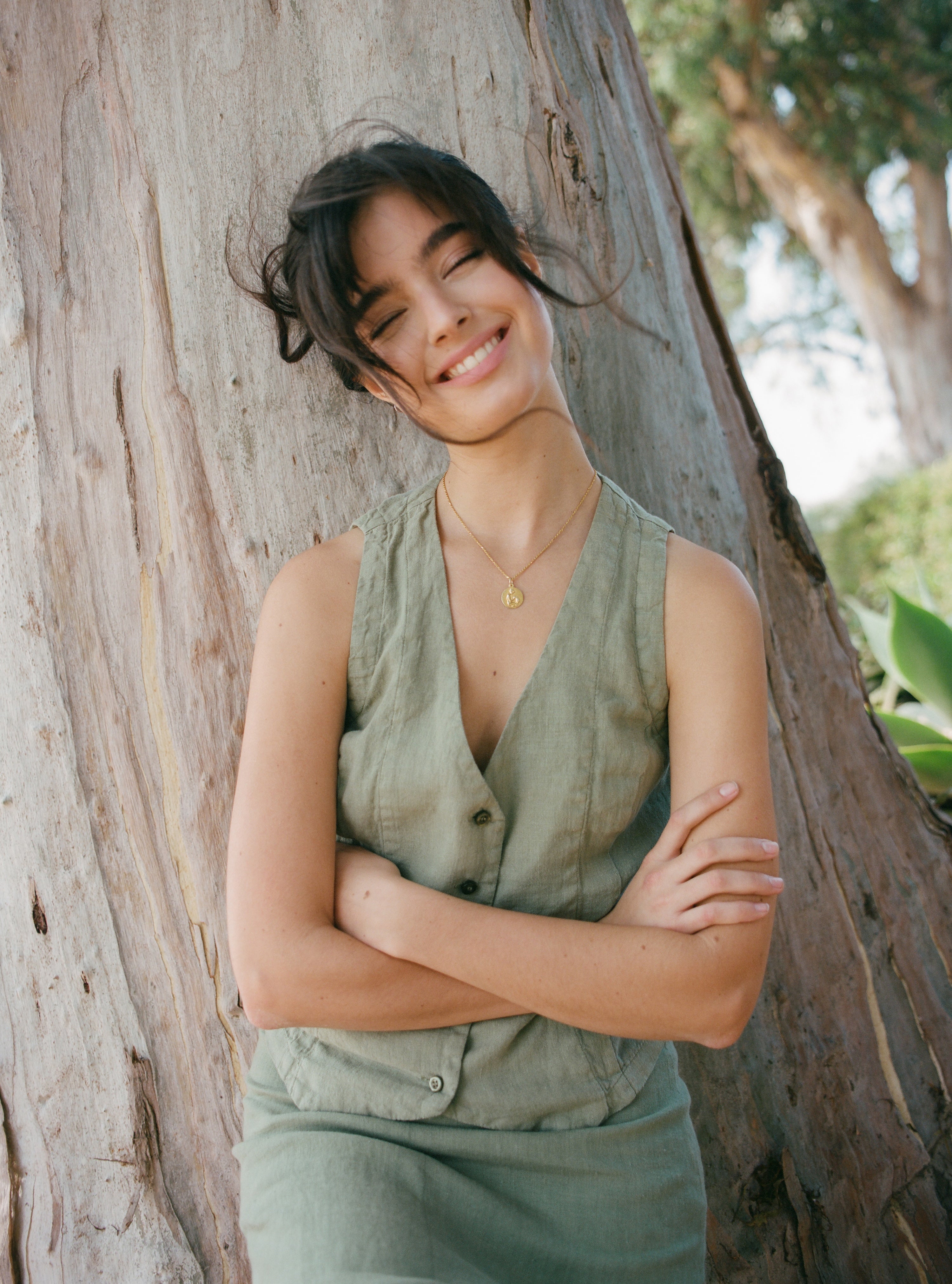 Female model, wearing a sage green colored sustainable 100% linen vest with matching Italian handcrafted buttons paired with a sage green linen skirt - VIR VITA
#color_sage