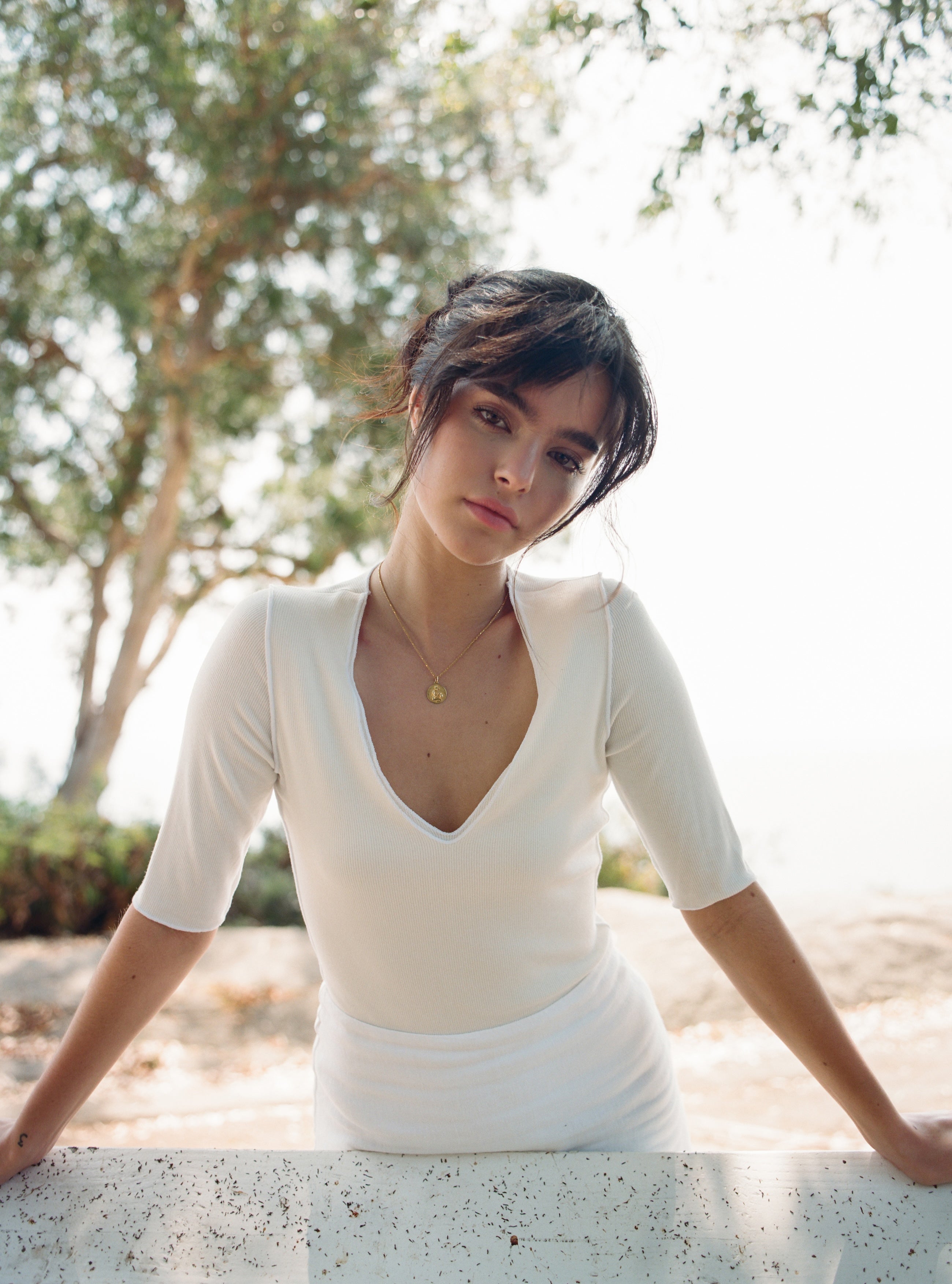 Female model wearing a 100% linen mini skirt with an A-line silhouette in white paired with a modal three-quarter sleeve v-neck top in white - VIR VITA
#color_white