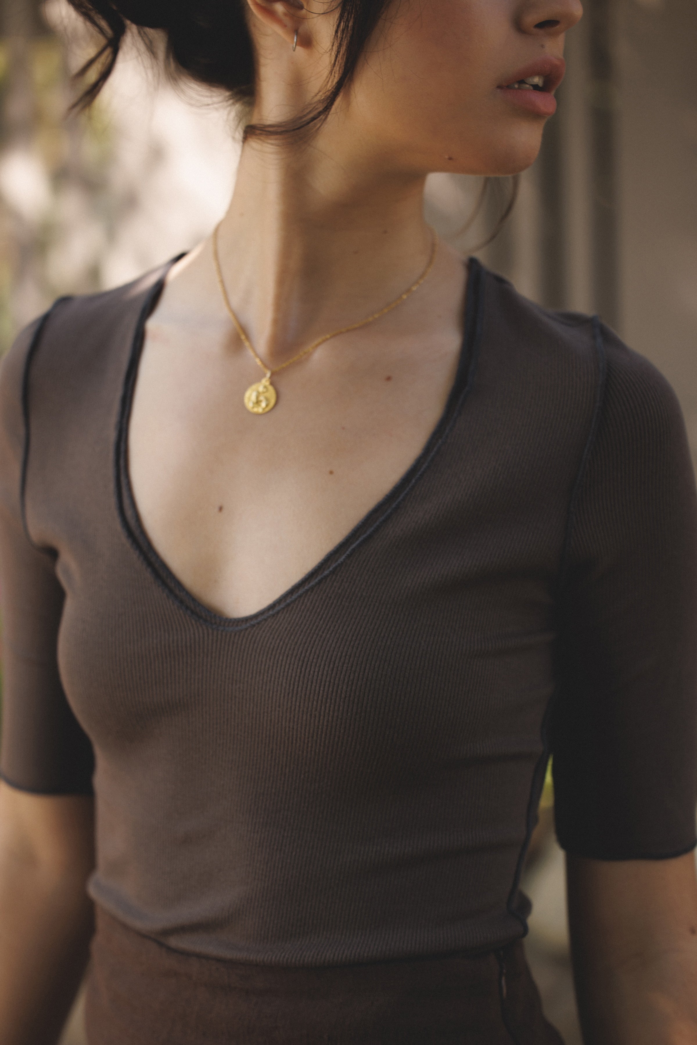 Female model wearing micro modal dark brown three-quarter sleeve v-neck top paired with a dark brown linen mini skirt. Classic, timeless, elegant, french style. - VIR VITA
#color_chestnut
