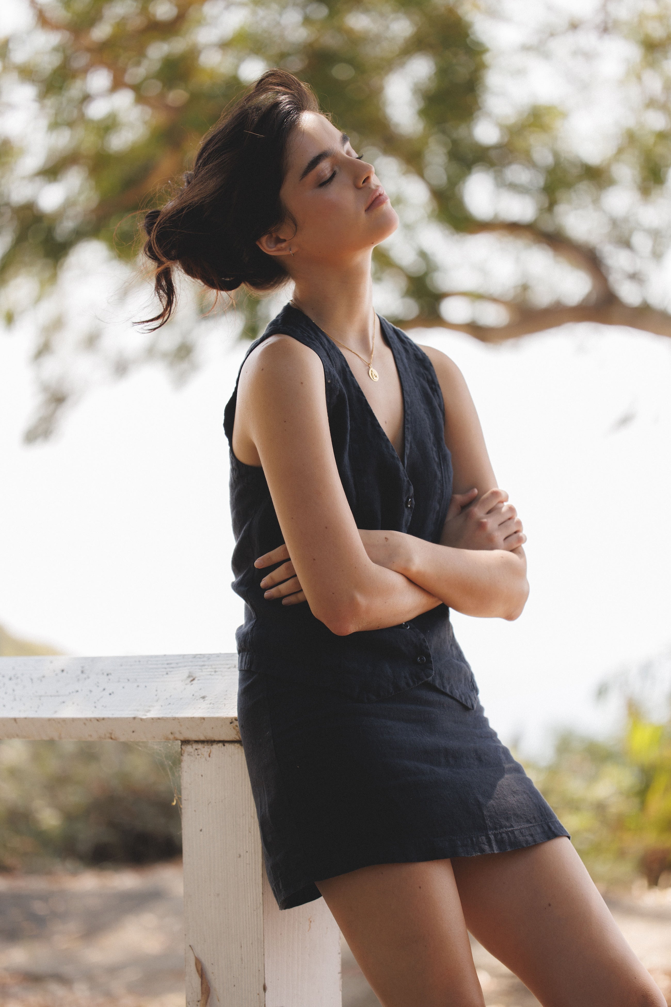 Female model, wearing a black colored sustainable 100% linen vest with matching Italian handcrafted buttons with a black linen mini skirt- VIR VITA
#color_black