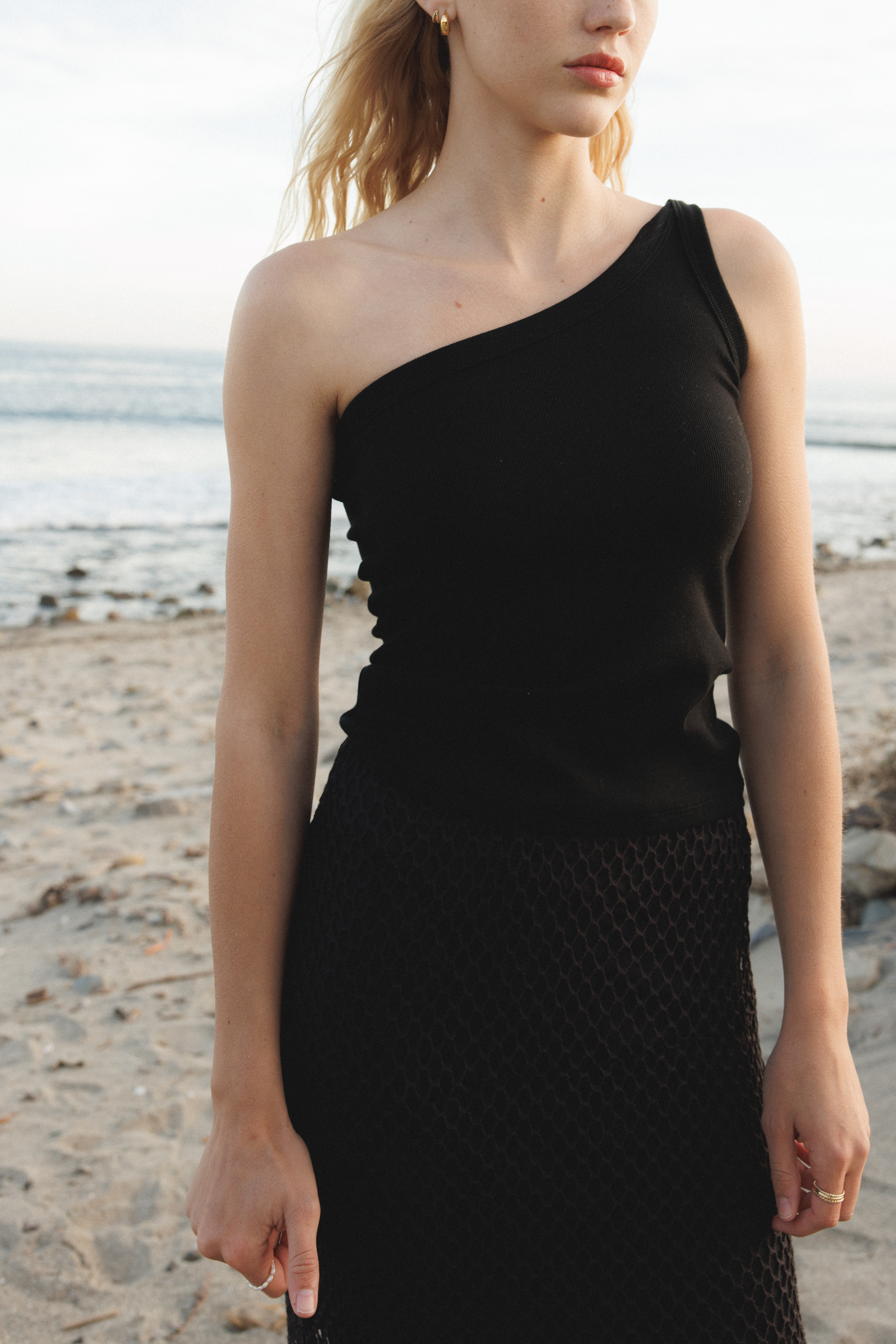 Female model wearing a sustainable asymmetrical one shoulder black top - VIR VITA
#color_black