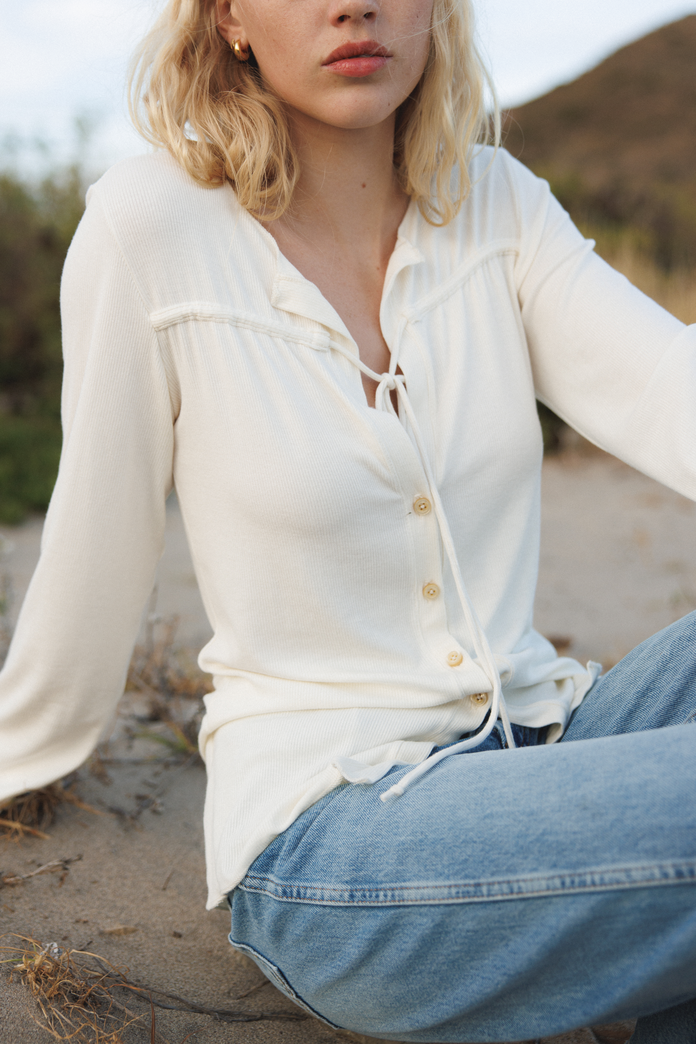 Female model wearing sustainable micro modal white buttery soft long sleeve ribbed top with tie and italian button. Romantic top. Classic, timeless, elegant, french style. natural organic clothing- VIR VITA
#color_coconut