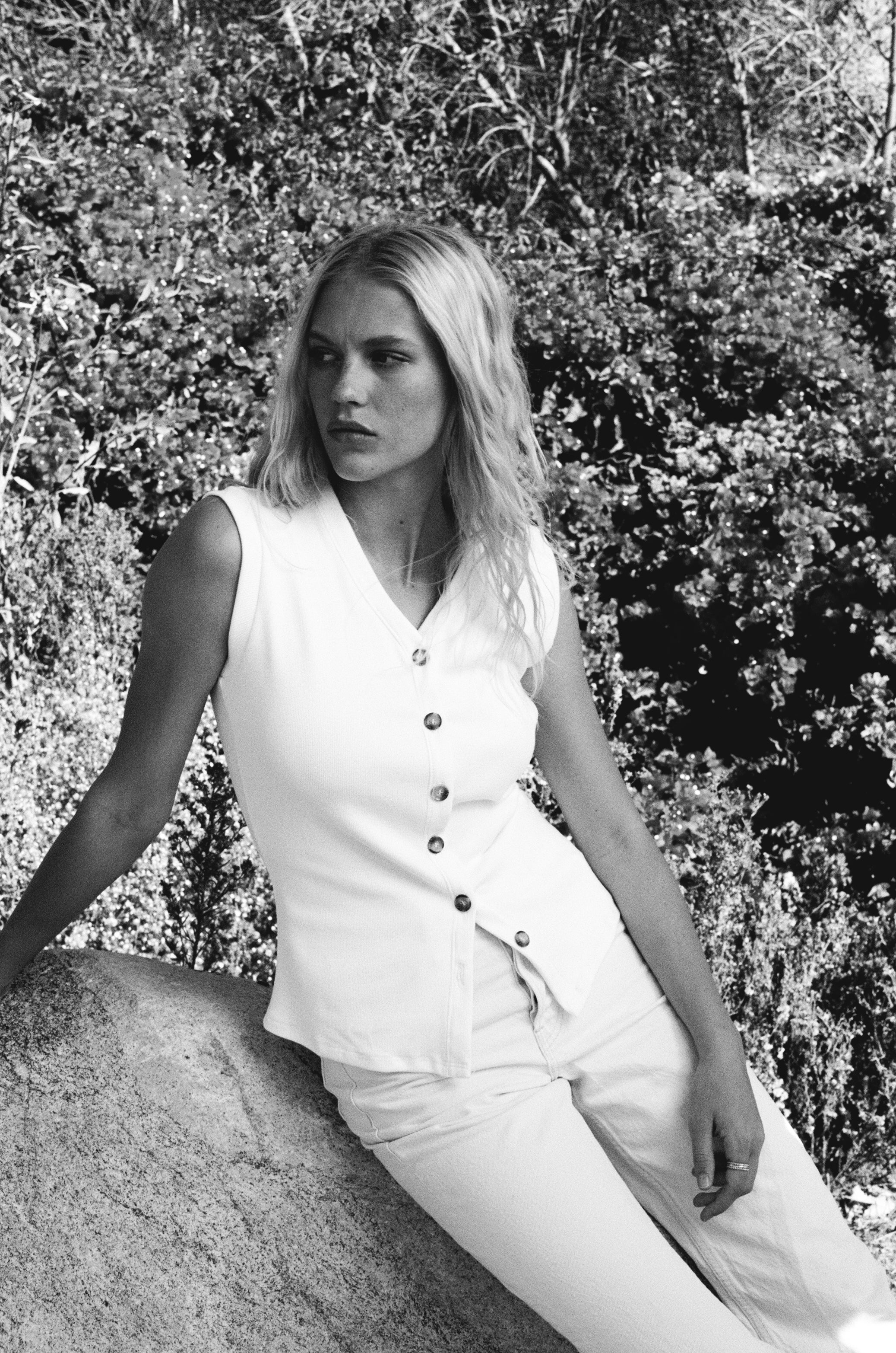 Female model wearing a sustainable supima cotton white ribbed vest with italian buttons paired with white jeans. Classic, timeless, elegant, french style. Natural organic clothing - VIR VITA
#color_white