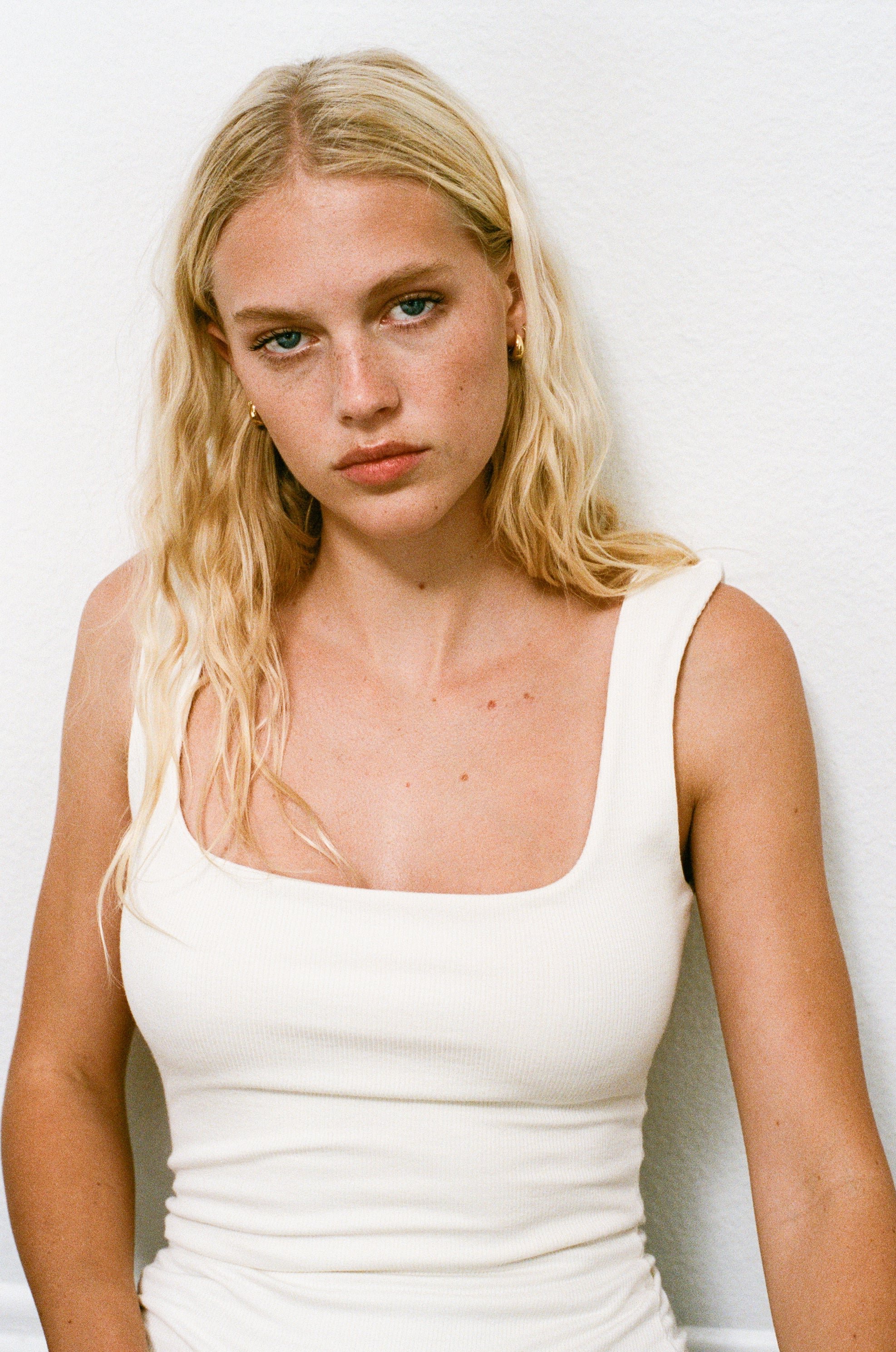 Female model wearing white square neck modal knit tank top inspired by 90s style - VIR VITA
#color_coconut