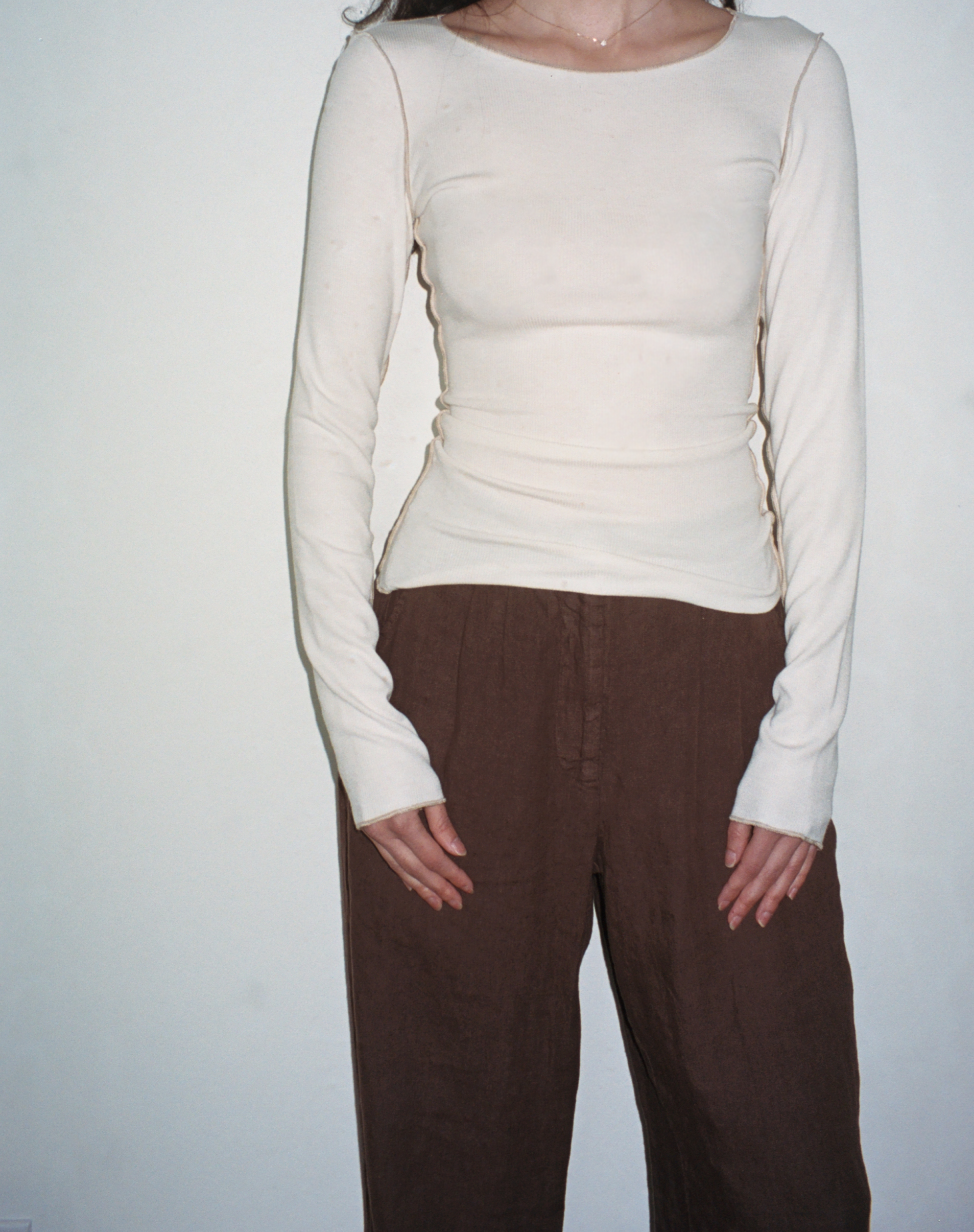 Female model wearing white sustainable micro modal long sleeve with merrow stitch detailing and brown linen trousers. Classic, timeless, elegant, french style. Natural organic clothing - VIR VITA

#color_coconut