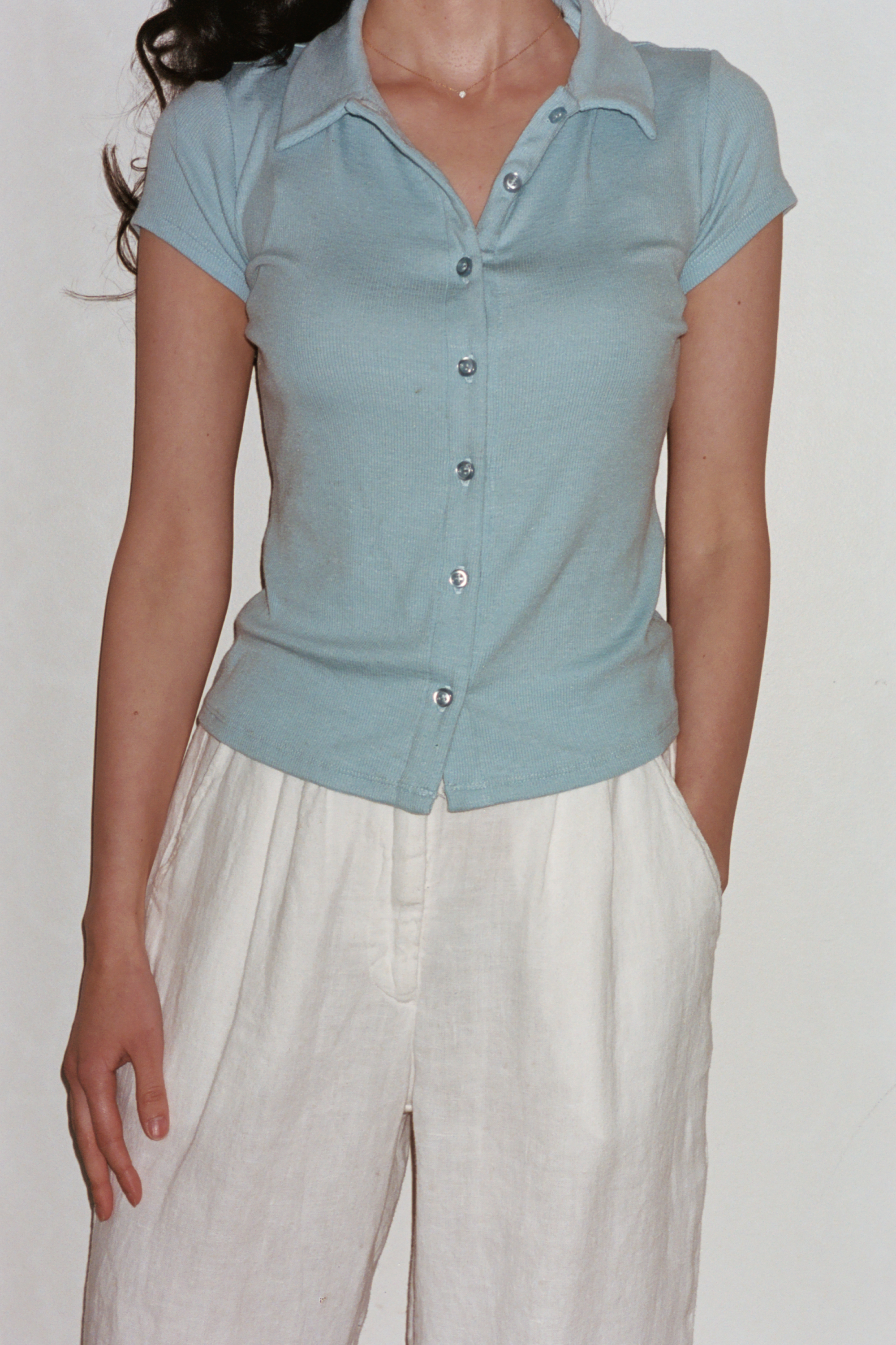 Female model wearing baby blue sustainable micro modal short sleeve ribbed polo top with italian button detailing. Classic, timeless, elegant, french style. Natural organic clothing - VIR VITA


#color_baby blue