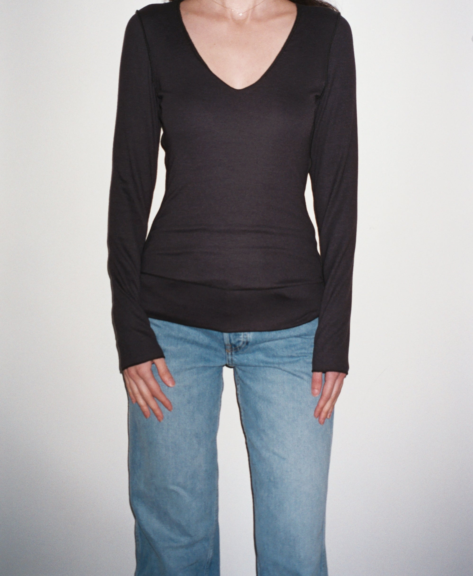 Female model wearing sustainable micro modal black buttery soft double lined v neck long sleeve ribbed top. Classic, timeless, elegant, french style. natural organic clothing- VIR VITA

#color_black