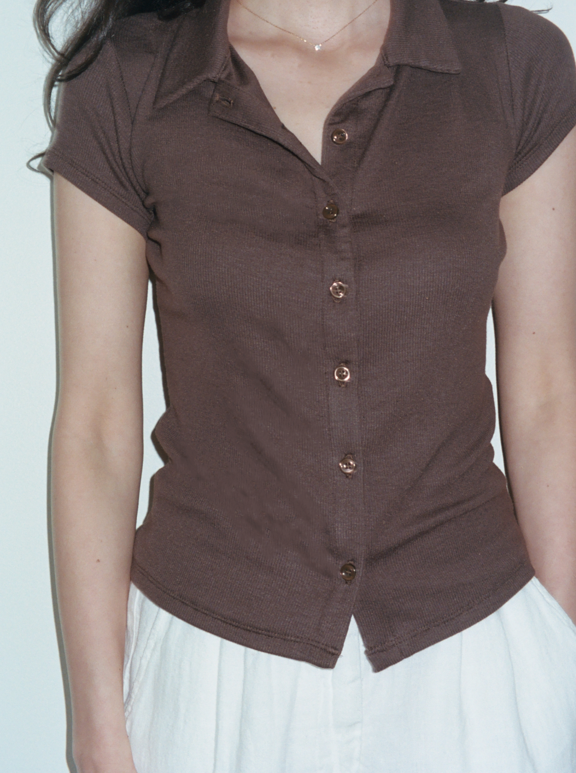 Female model wearing brown sustainable micro modal short sleeve ribbed polo top with italian button detailing. Classic, timeless, elegant, french style. Natural organic clothing - VIR VITA


#color_chestnut