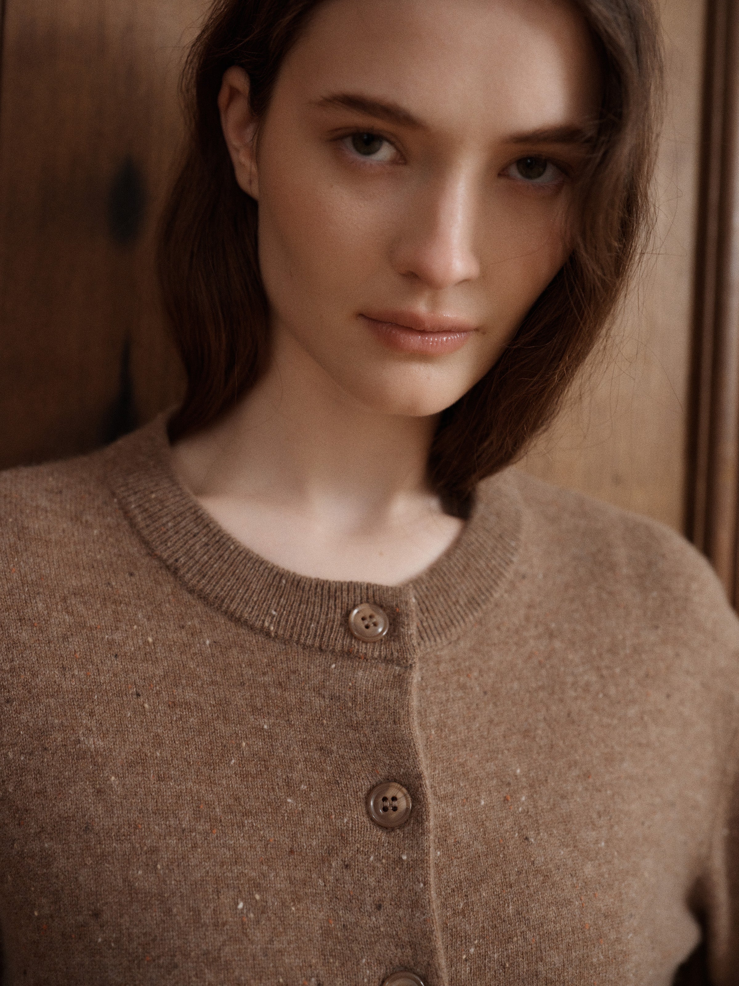 Female model posing in a speckled light brown cardigan made in soft cashmere with slouchy details to create a relaxed silhouette. - VIR VITA
#color_toastedwalnut