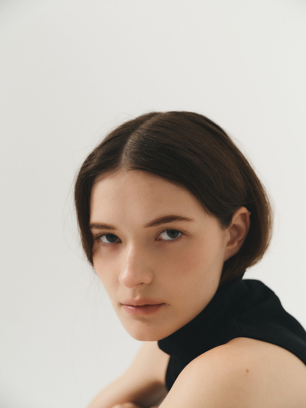 Female model wearing a black fitted sleeveless turtleneck crafted from a fine wool, cashmere and silk blend. - VIR VITA
#color_black