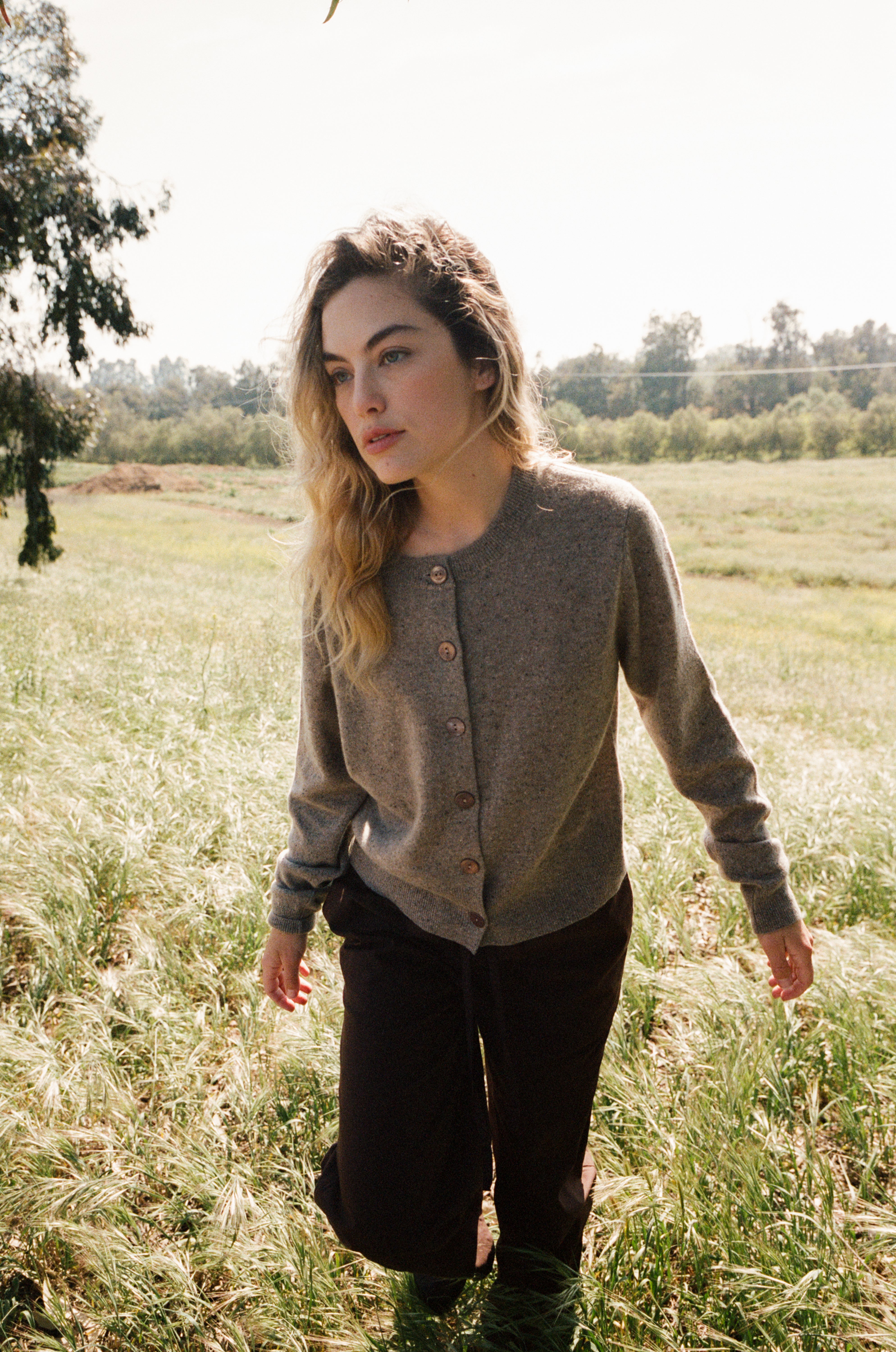Female model standing in a field wearing a  light brown ultra-soft luxurious cashmere button up cardigan paired with dark brown drawstring pants - VIR VITA
#color_walnut