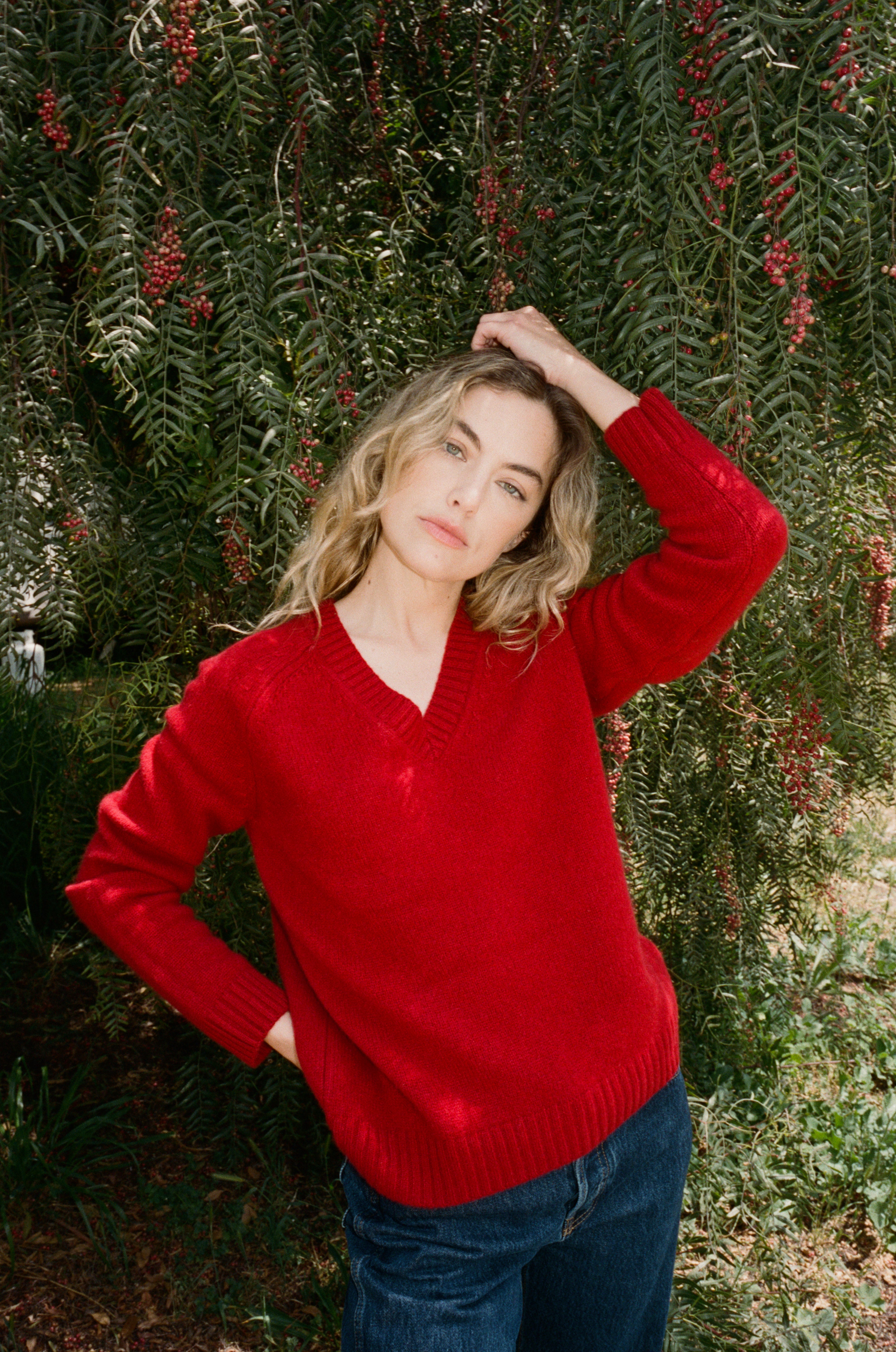 Female model wearing an ultra-soft luxurious cashmere pullover sweater featuring a v-neck design in red paired with dark blue jeans - VIR VITA
#color_cherry