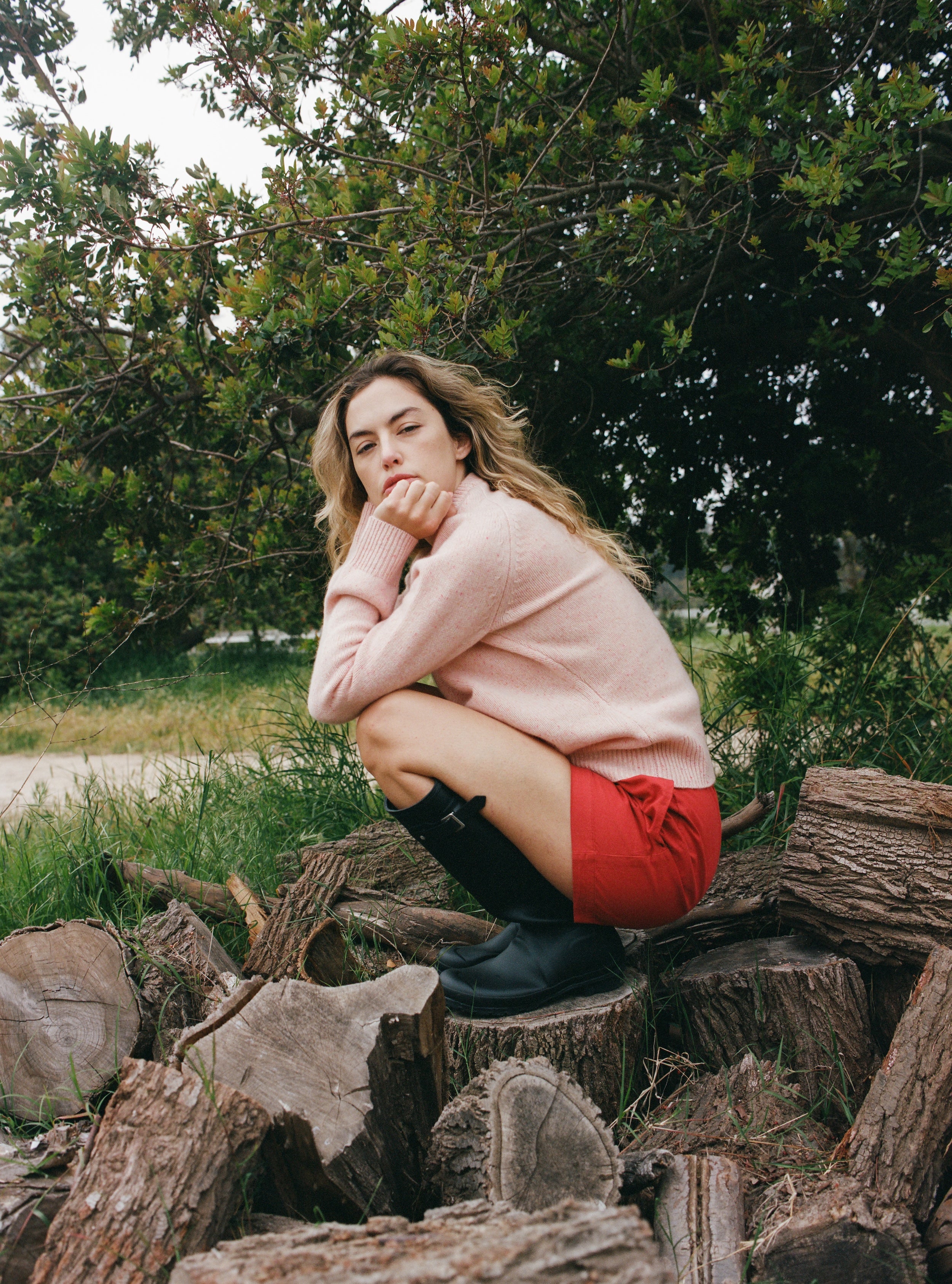 Female model wearing a light pink ultra-soft luxurious cashmere pullover sweater featuring a classic silhouette and raglan sleeves paired with red cotton poplin shorts - VIR VITA
#color_rosewater