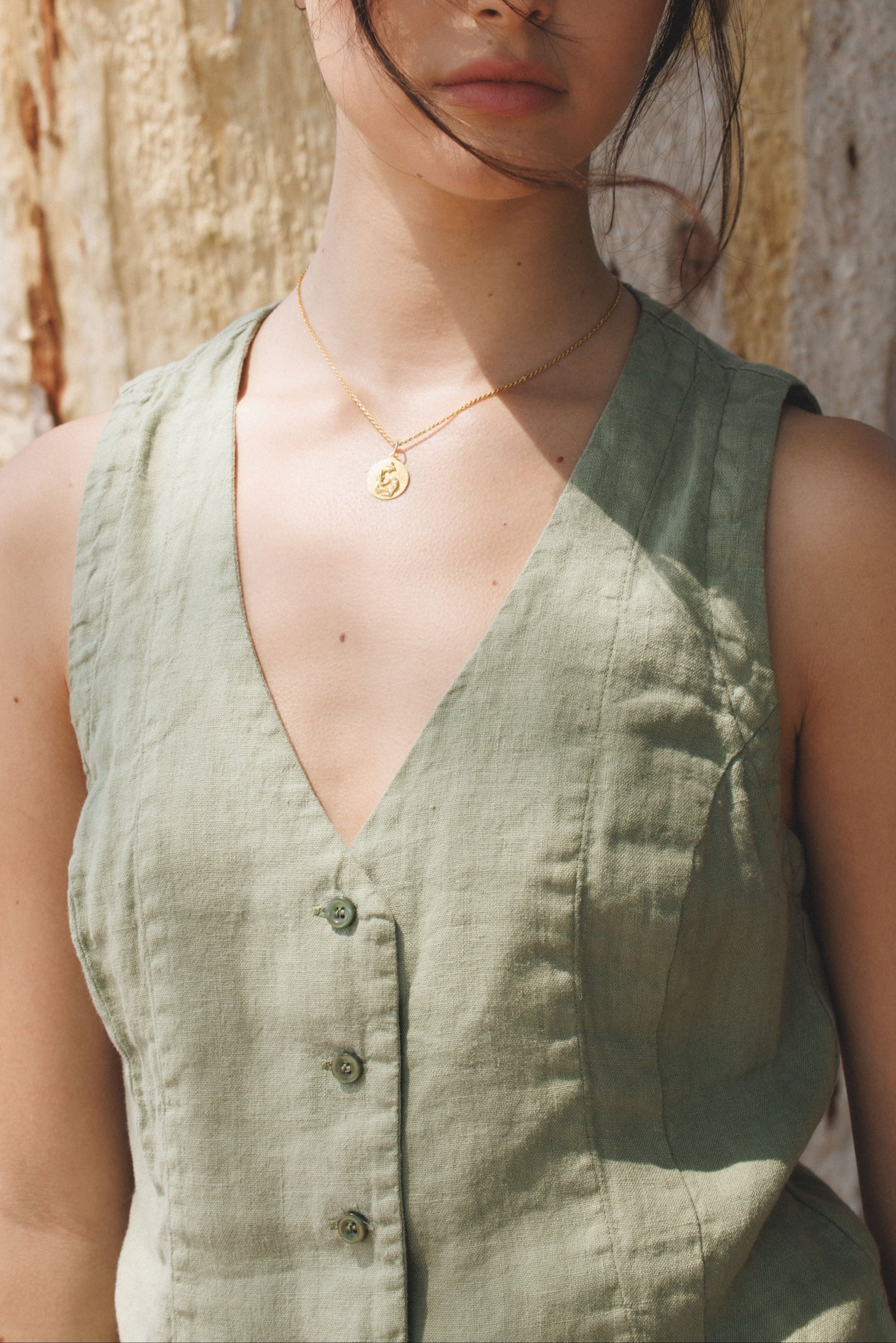 Female model,  wearing a sage green colored sustainable 100% linen vest with handcrafted matching Italian buttons - VIR VITA
#color_sage