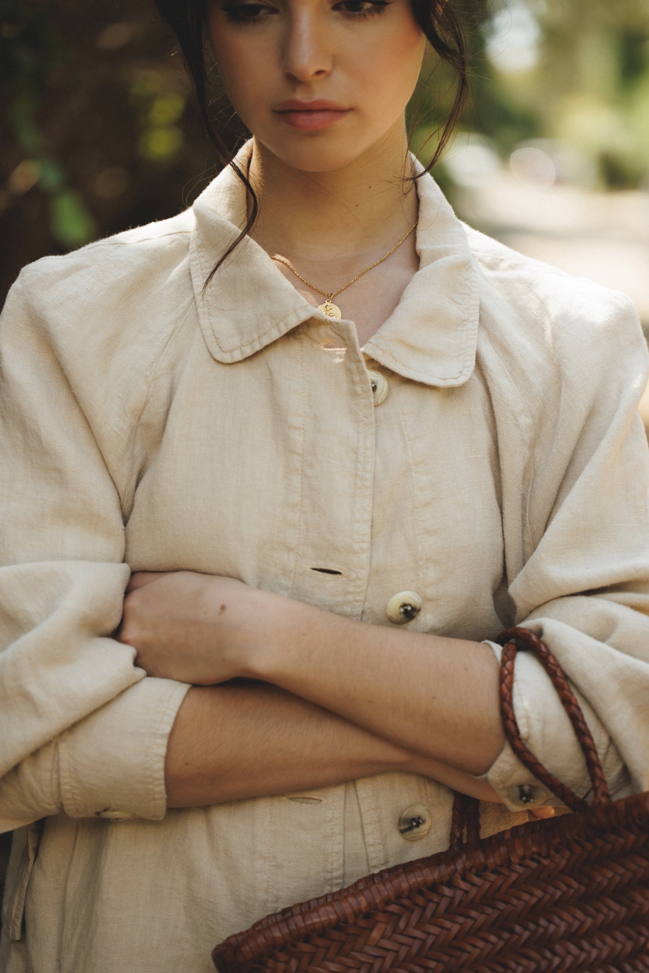 Female model wearing sustainable beige 100% linen barn jacket holding a leather basket bag- VIR VITA

#color_beige 

