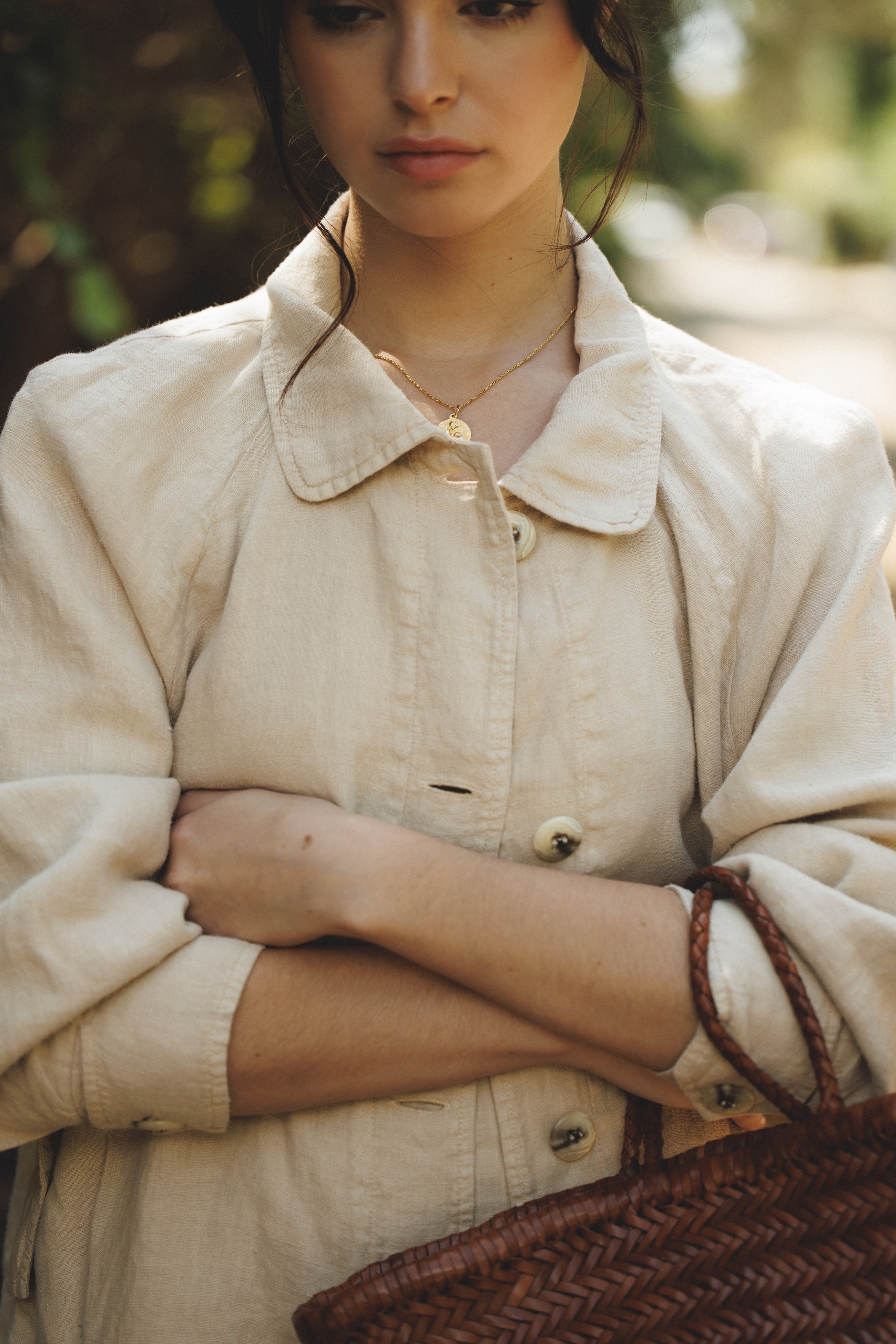 Female model wearing sustainable beige linen barn jacket holding a leather basket bag- VIR VITA

#color_beige 
