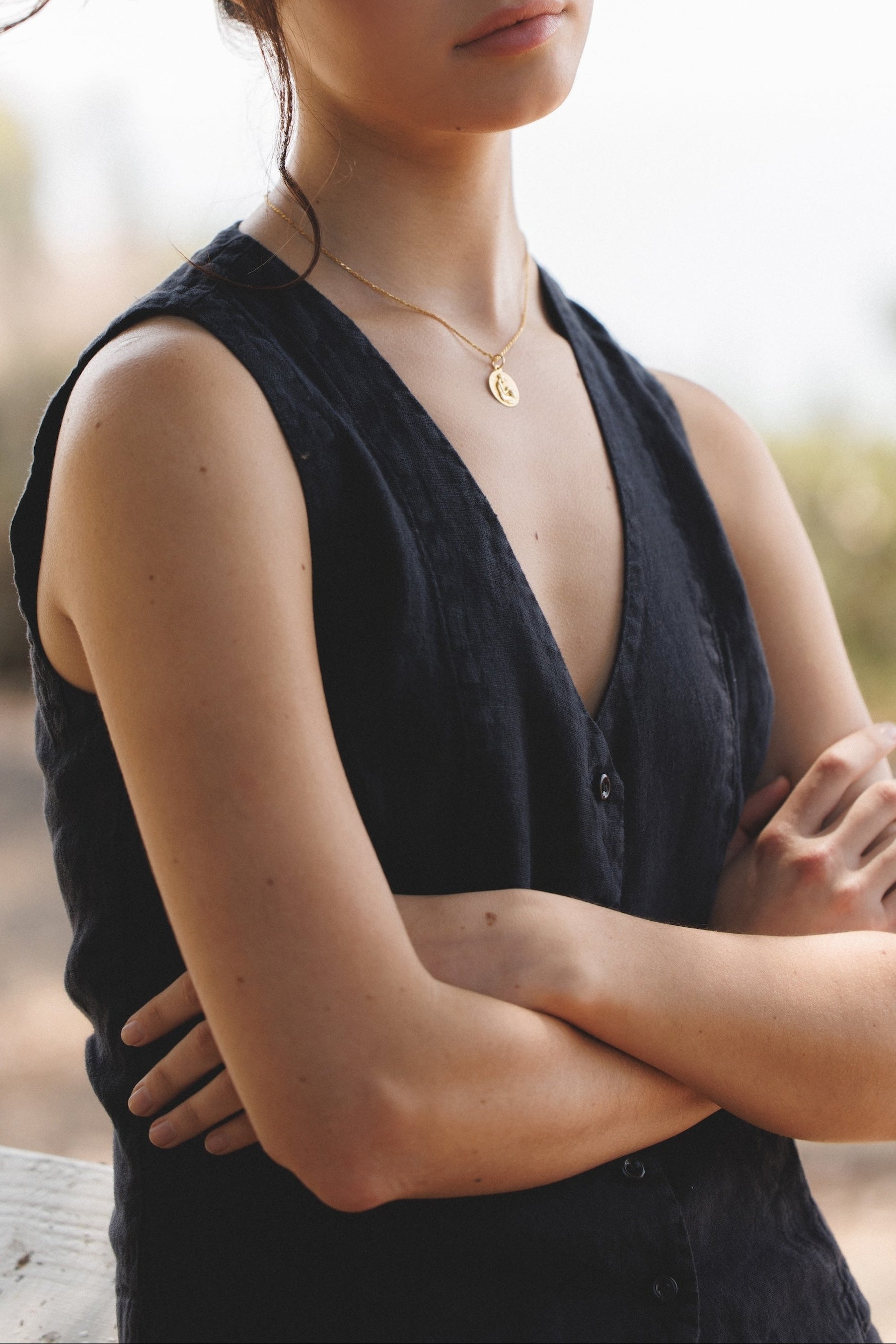 Female model,  wearing a black colored sustainable 100% linen vest  with matching Italian handcrafted buttons paired with a black linen mini skirt- VIR VITA
#color_black
