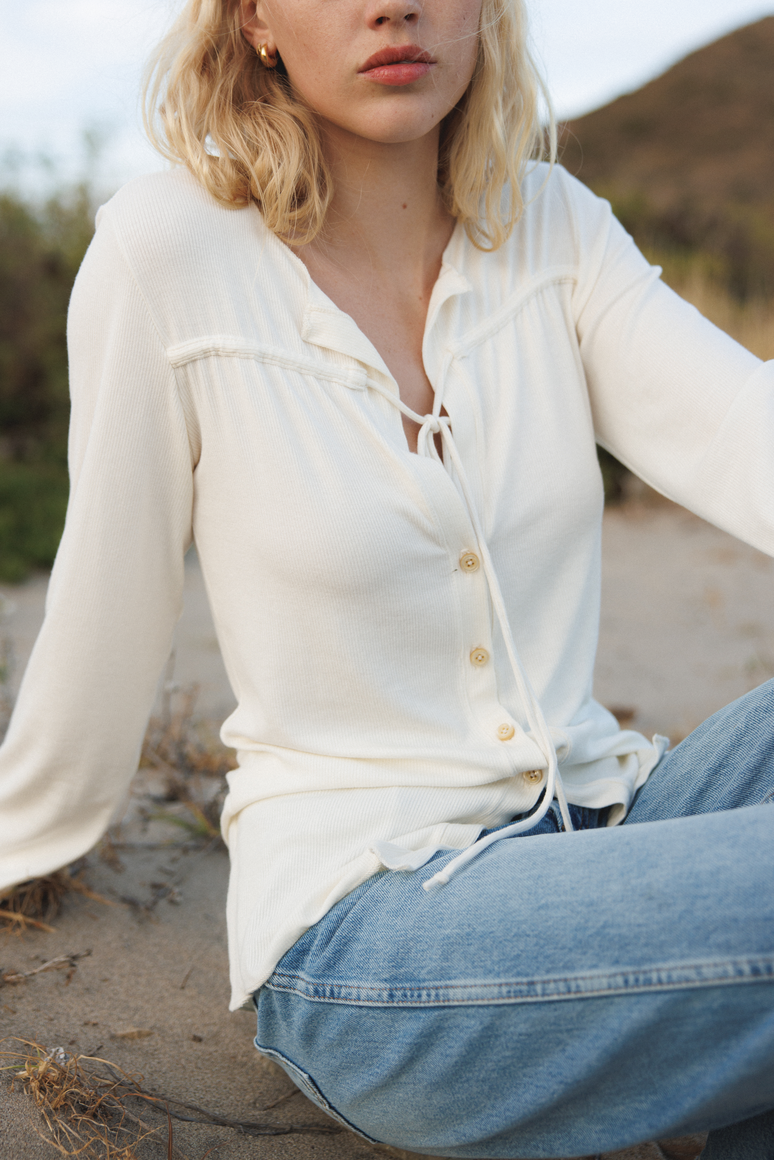 Female model wearing sustainable micro modal white buttery soft long sleeve ribbed top with tie and italian button. Romantic top. Classic, timeless, elegant, french style. natural organic clothing- VIR VITA


#color_coconut