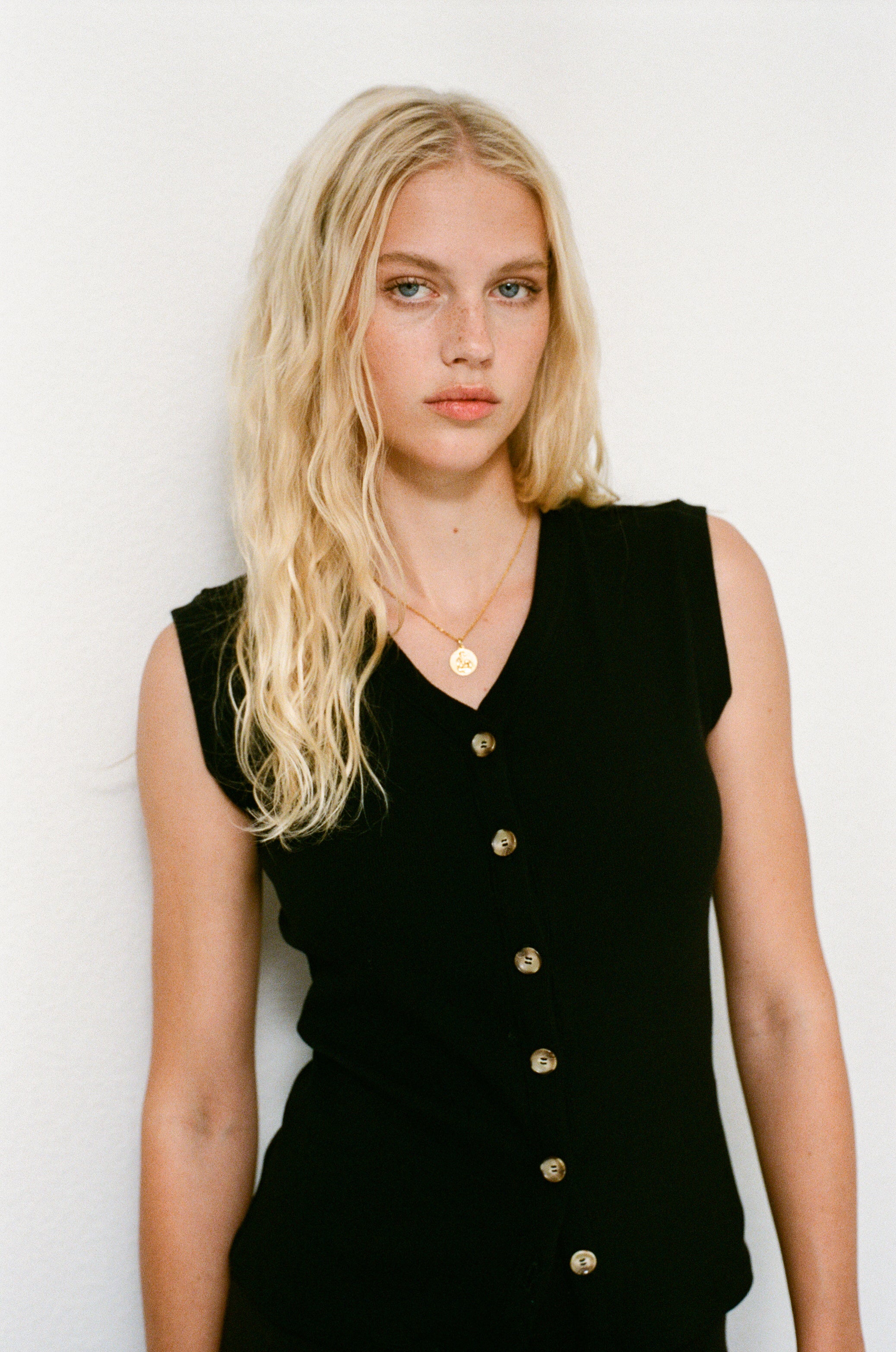 Female model wearing sustainable supima cotton black ribbed vest with italian buttons  Classic, timeless, elegant, french style. Natural organic clothing - VIR VITA

#color_black