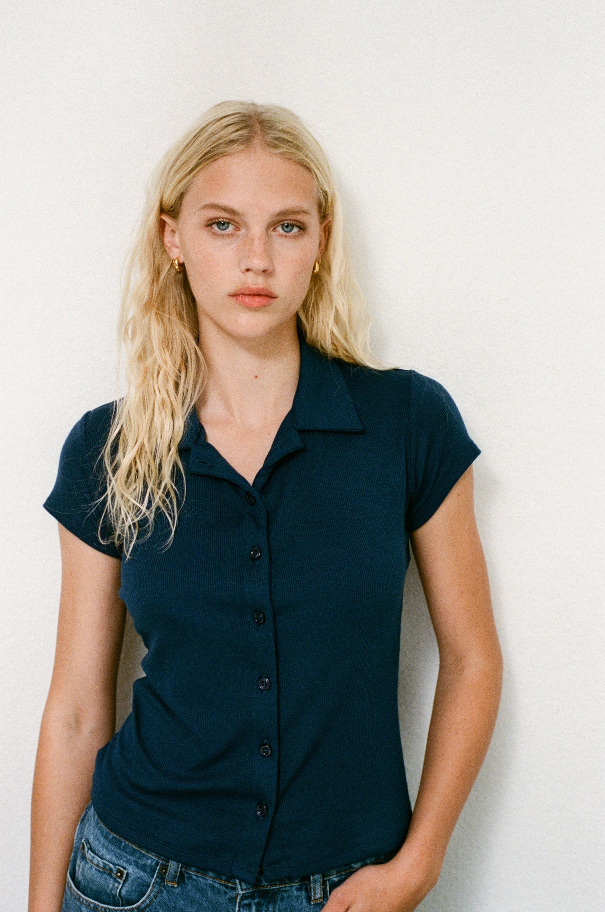 Female model wearing navy vlue sustainable micro modal short sleeve ribbed polo top with italian button detailing. Classic, timeless, elegant, french style. Natural organic clothing - VIR VITA

#color_navy